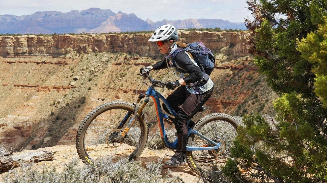 Mountain biker riding on rocky trail with scenic Hurricane Utah canyon background at Hurricane Mountain Bike Festival