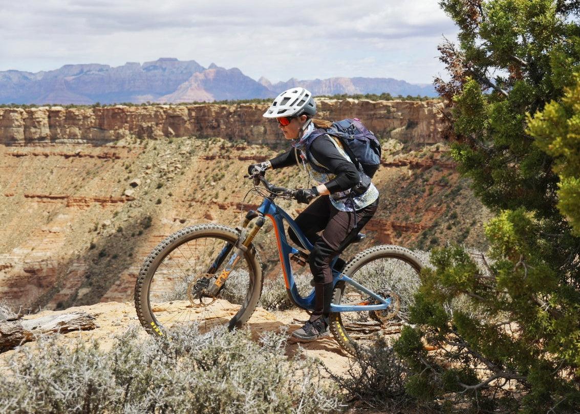 Mountain biker riding on rocky trail with scenic Hurricane Utah canyon background at Hurricane Mountain Bike Festival