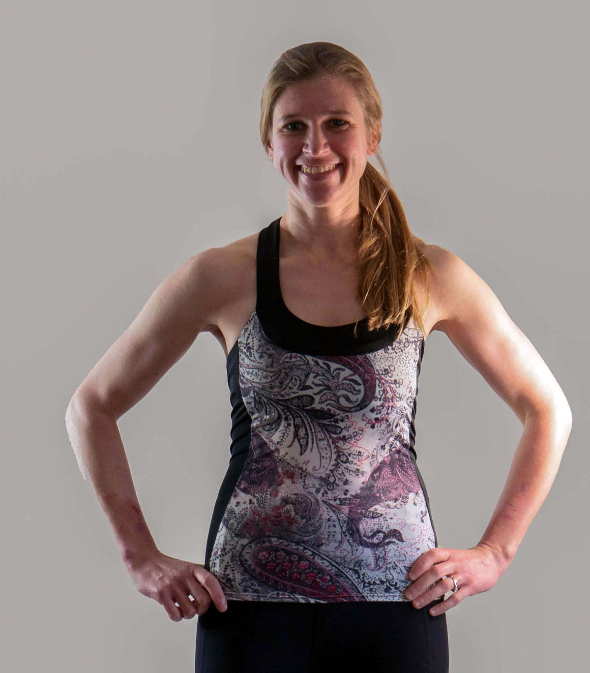 Paisley Greys women's T-back top featuring lightweight, moisture-wicking fabric with ventilation ports and a built-in bra for comfort and support.