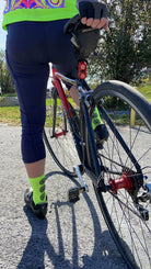 Cyclist wearing Moxie Socks - Moxie Yellow, featuring moisture-wicking fabric and 6-inch cuff.