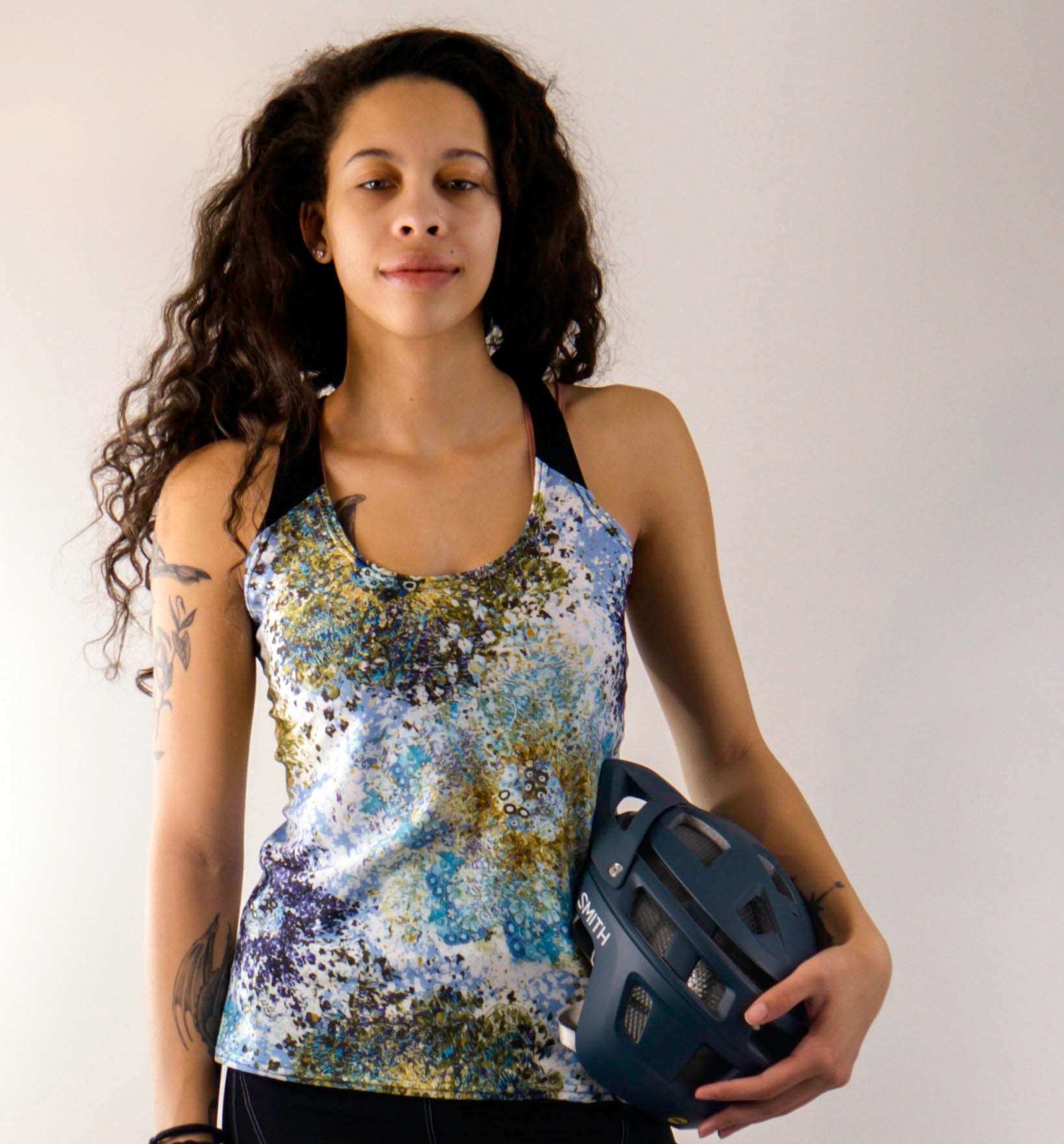 Racerback Starlight top with mesh back detail and two pockets, worn by woman holding helmet.