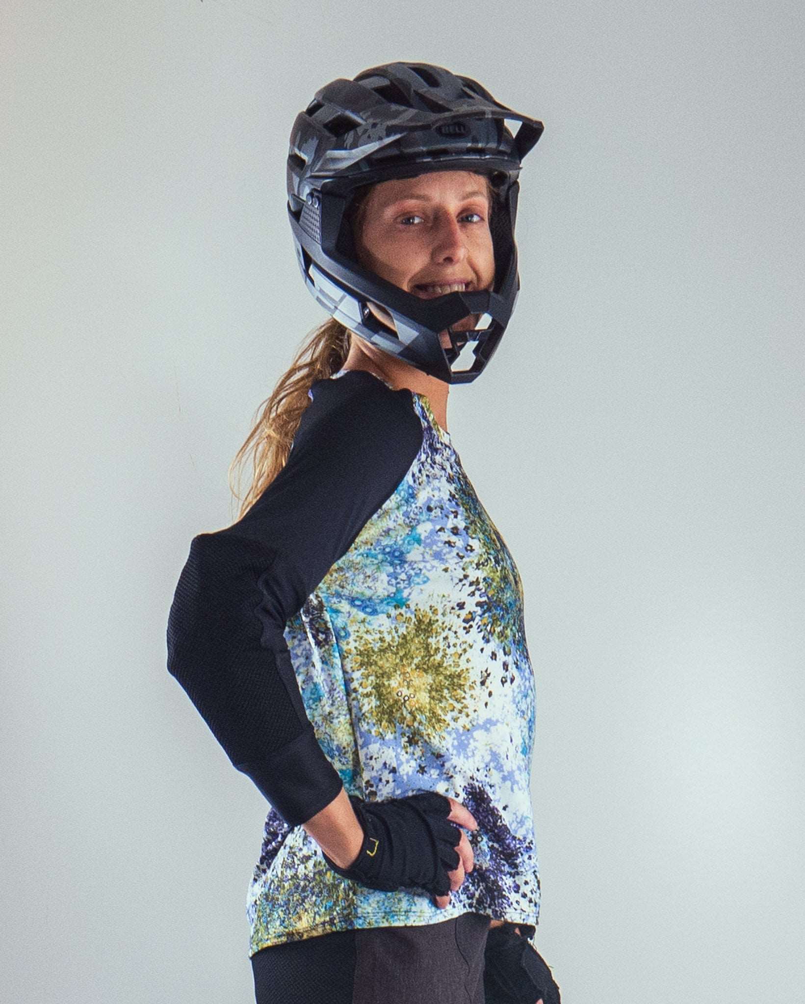 Mountain Bike Top Jet Black with integrated elbow pad pockets, durable stretch fabric, worn by a cyclist with helmet.