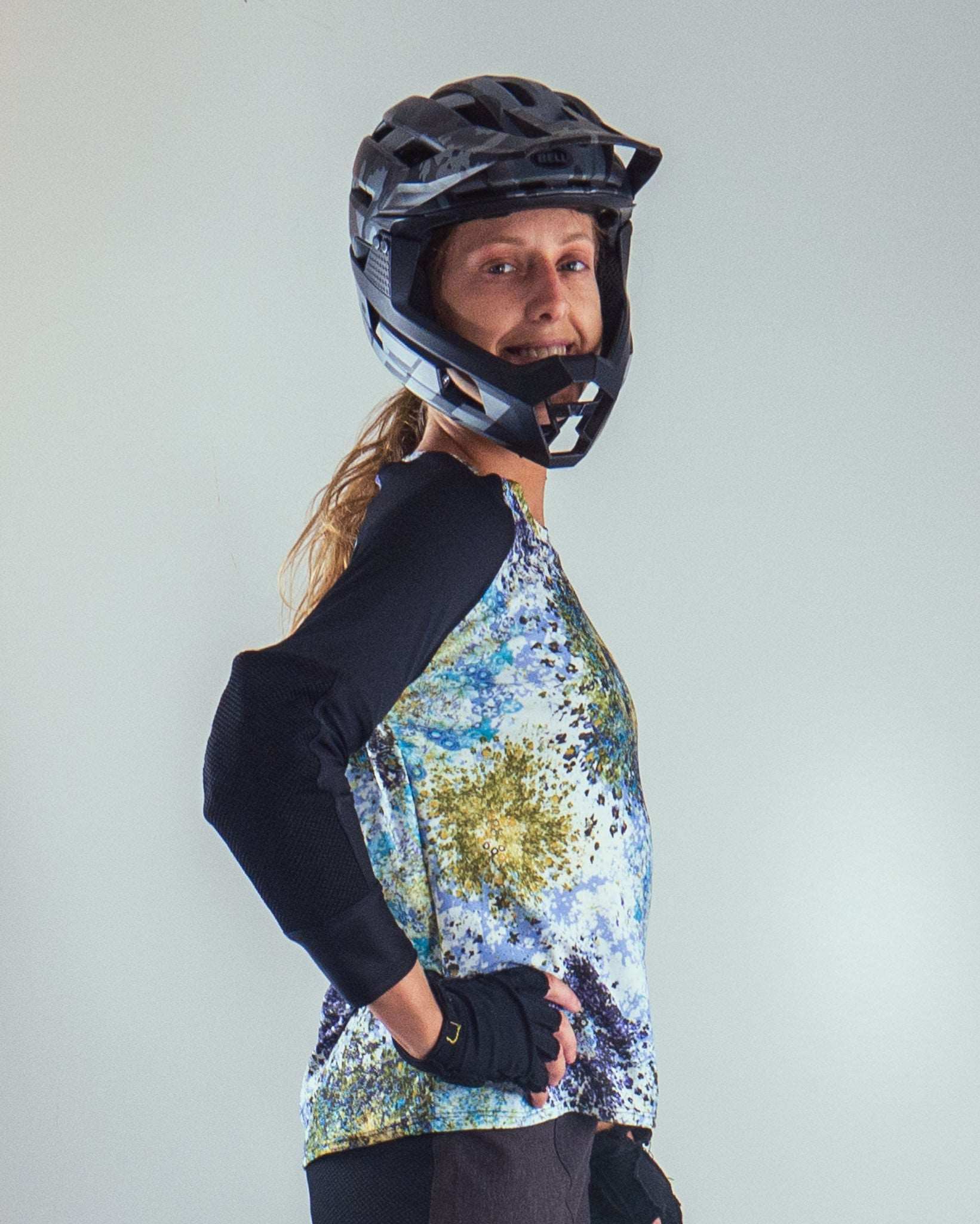 Mountain bike jersey with starlight design, featuring pockets for G-Form elbow pads, worn by a woman biker.