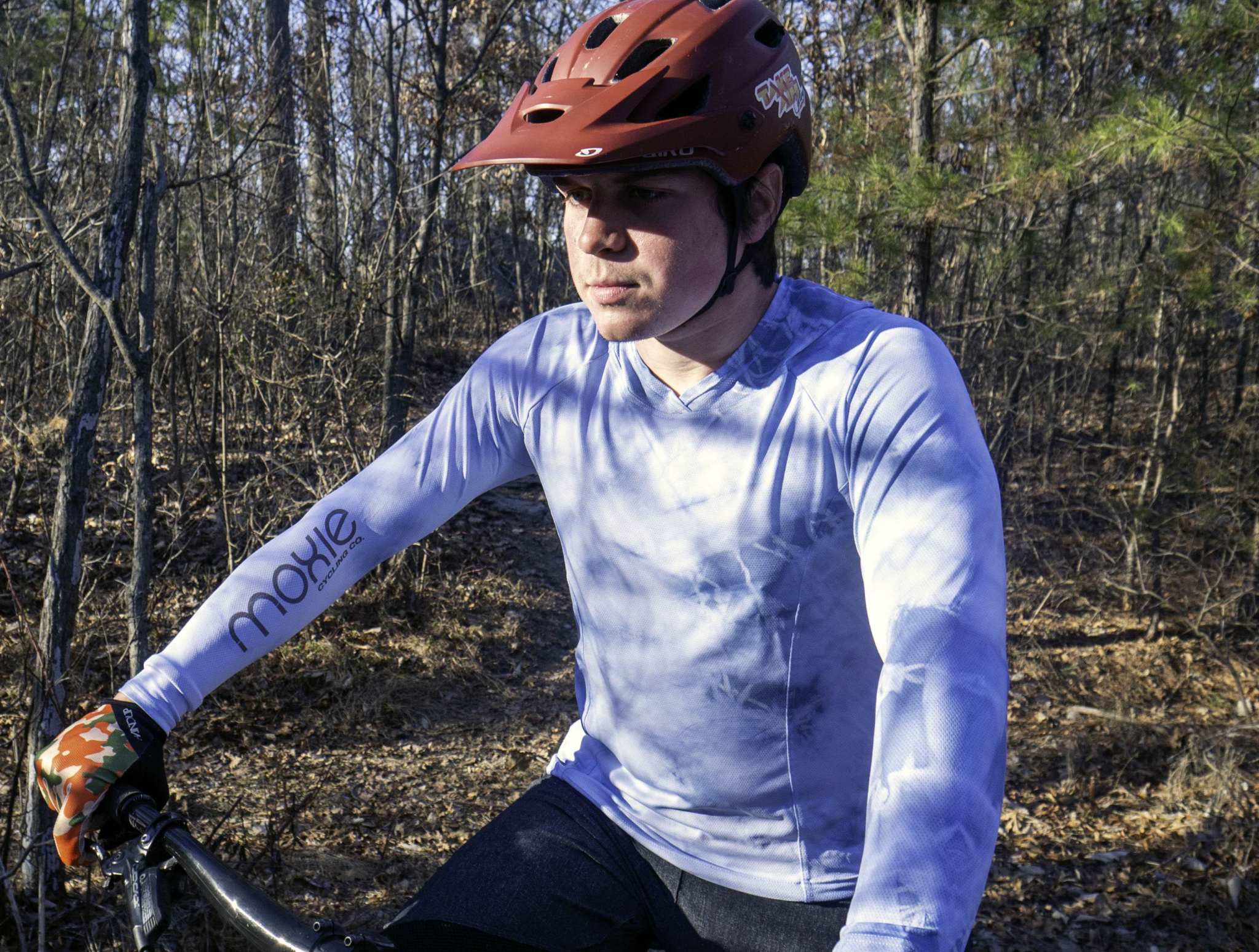All Gender Hoodie with moisture-wicking fabric worn by cyclist in forest.