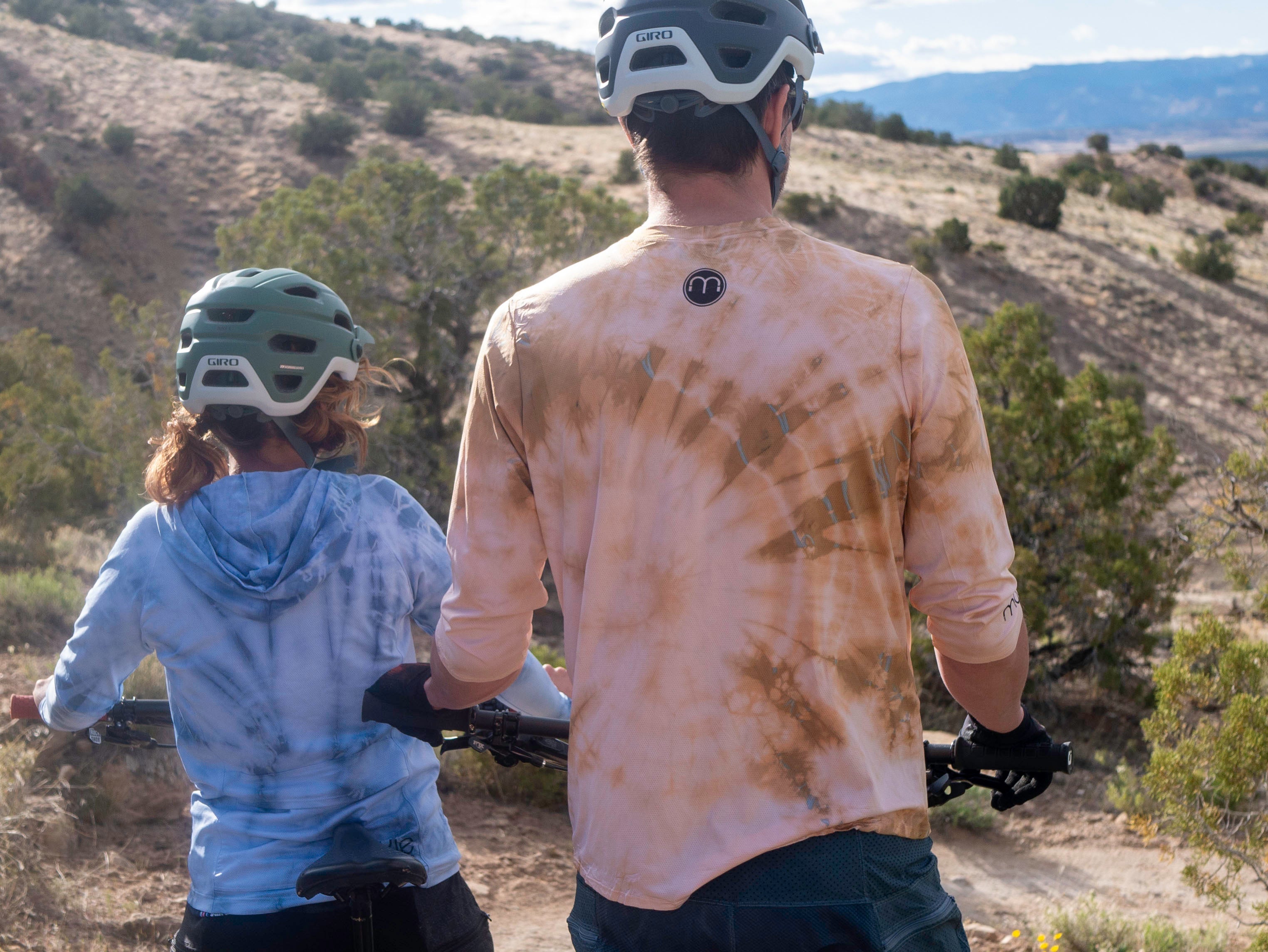 All Gender Jersey for mountain biking, hand-dyed soft mesh, relaxed fit, worn by cyclists on a trail.