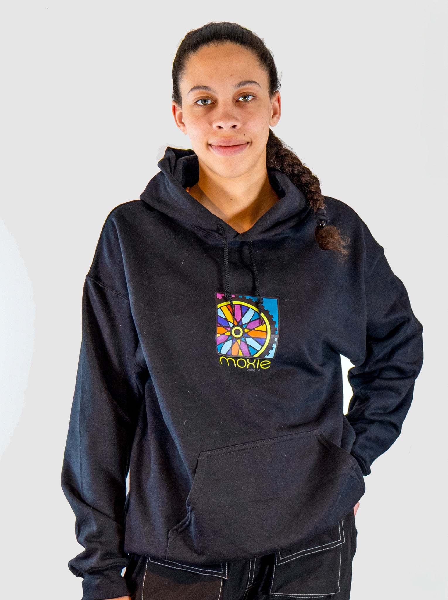 Person wearing a black hoodie with a colorful logo on a white background