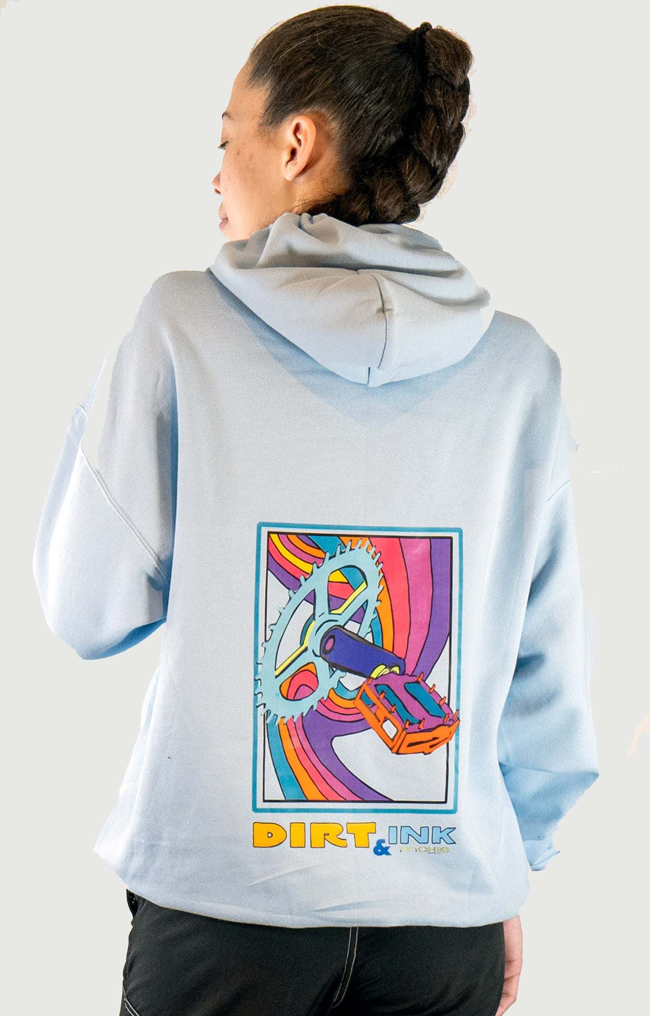 Person wearing a light blue hoodie with a colorful graphic and 'Dirt & Ink' text on the back.