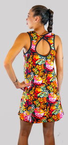 Woman wearing a colorful floral dress on a plain background