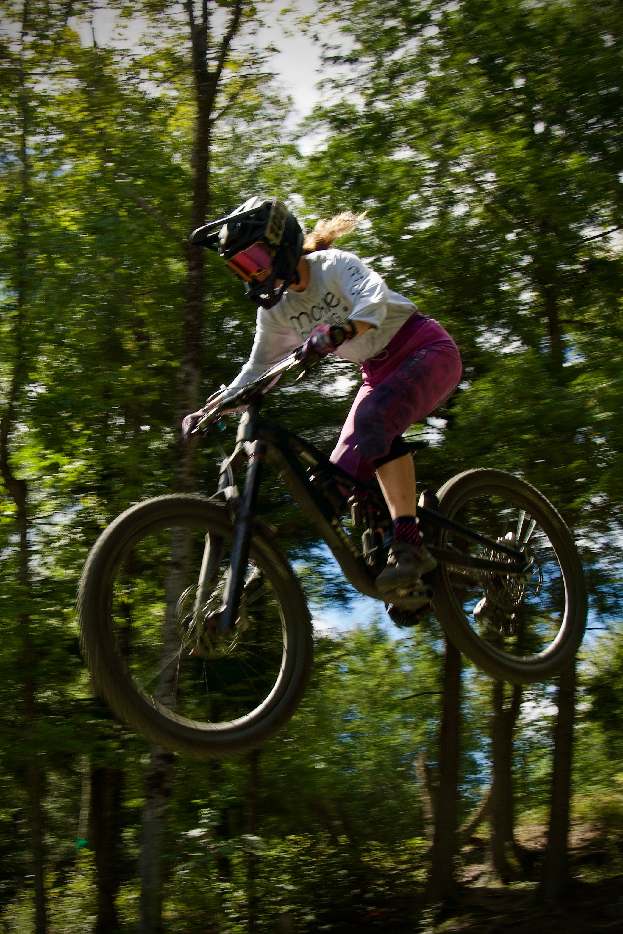 Moxie Cycling ambassador doing a jump on her bike in G-From trail pants