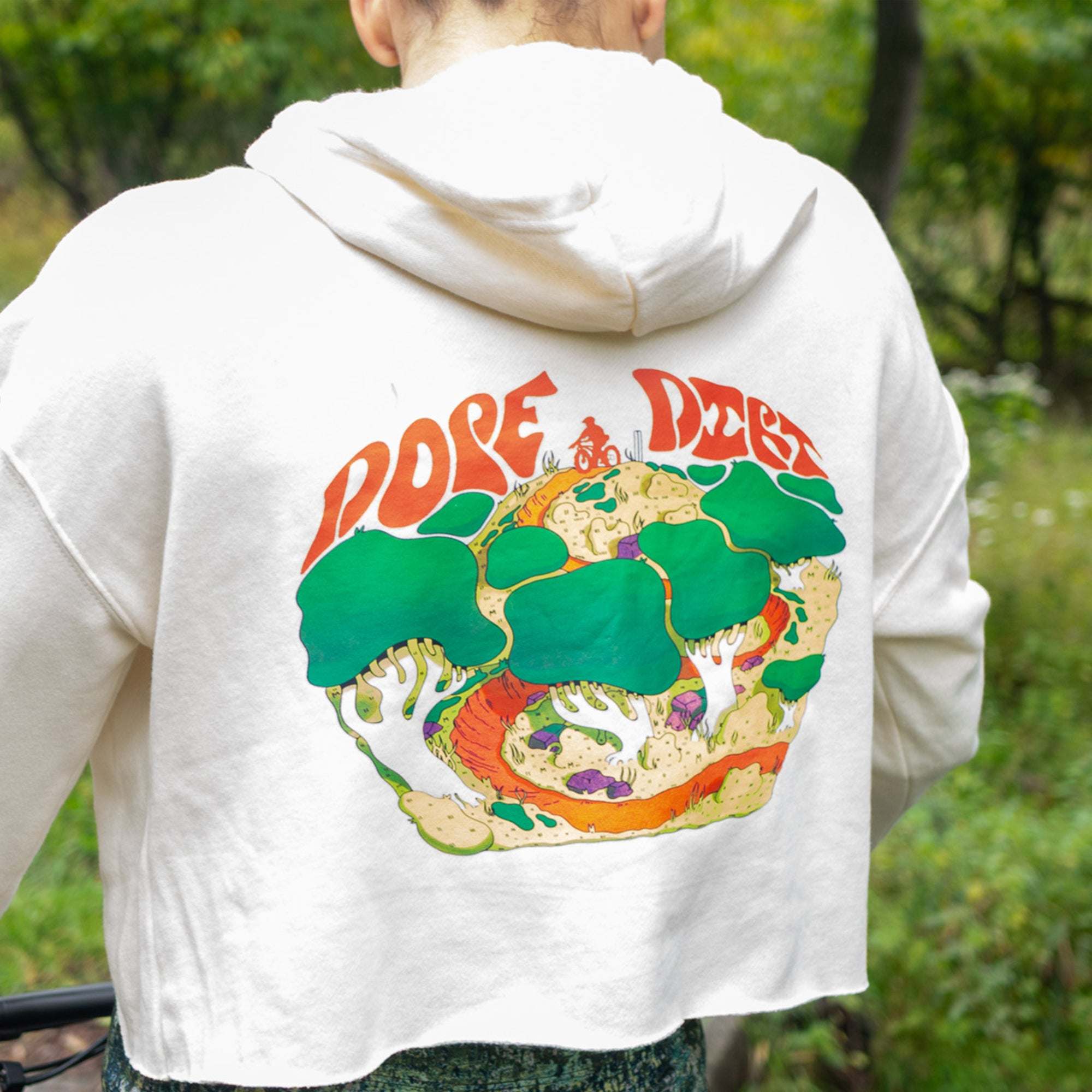 Cropped white Moxie Hoodie in soft fabric, featuring a large colorful mushroom and forest graphic with red lettering on the back.