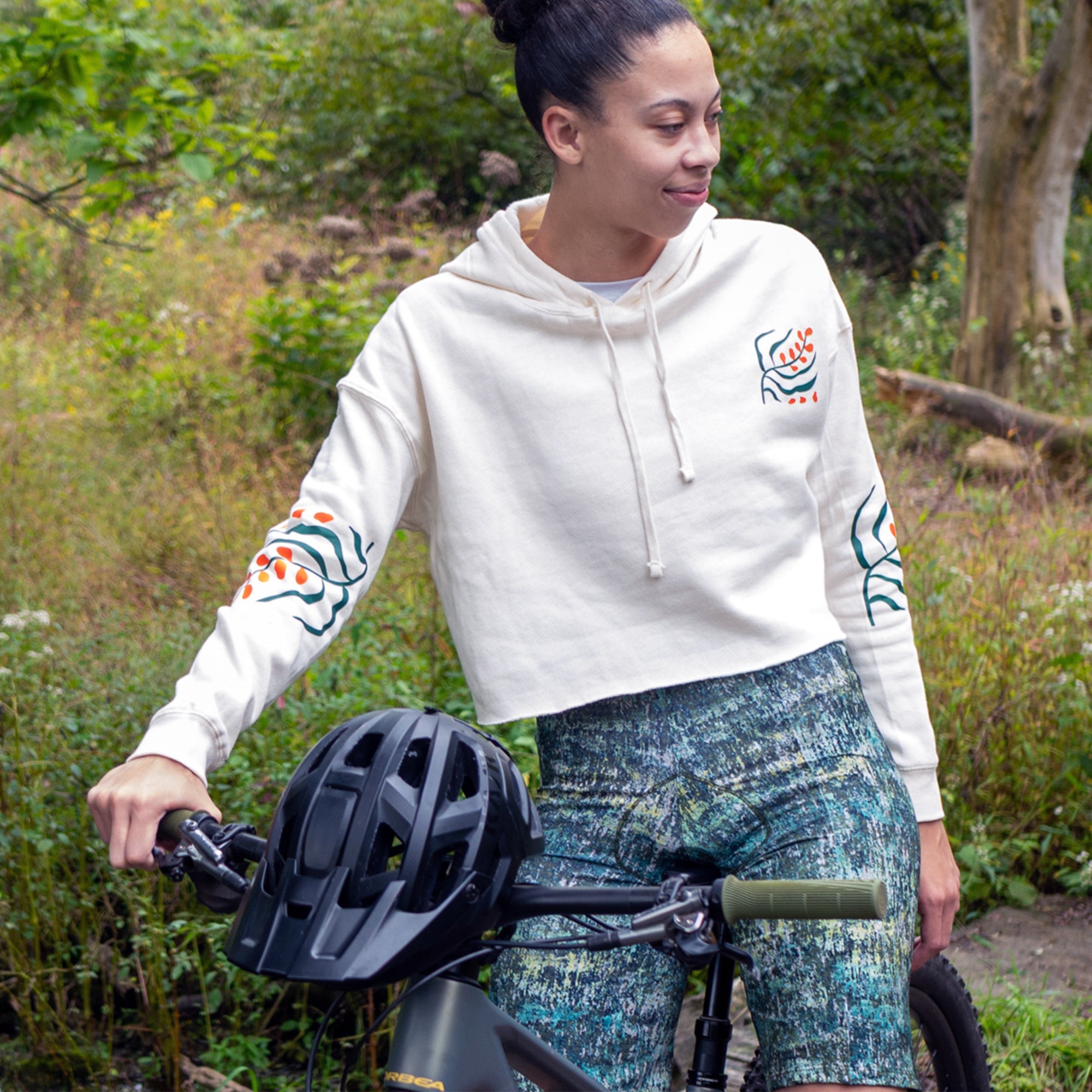 Moxie Hoodie, white cropped performance hoodie with drawstrings and colorful graphic accents on the chest and sleeves.