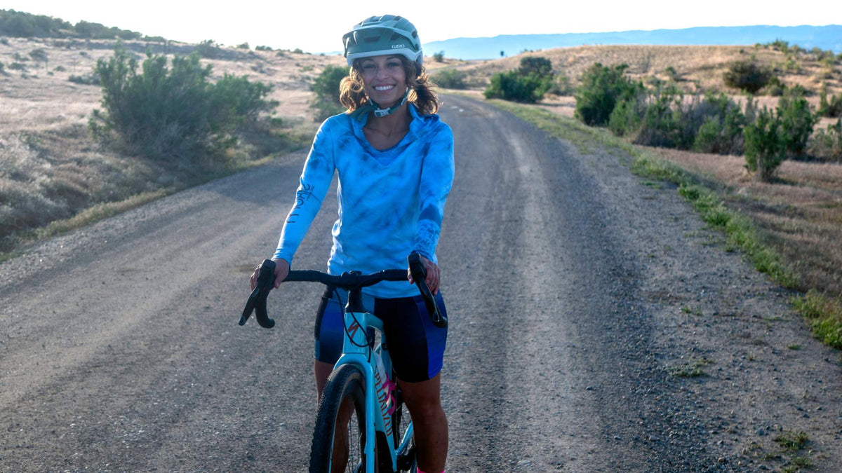 Women's bike shorts with 7" inseam, featuring Italian chamois, worn by a cyclist on a rural road.