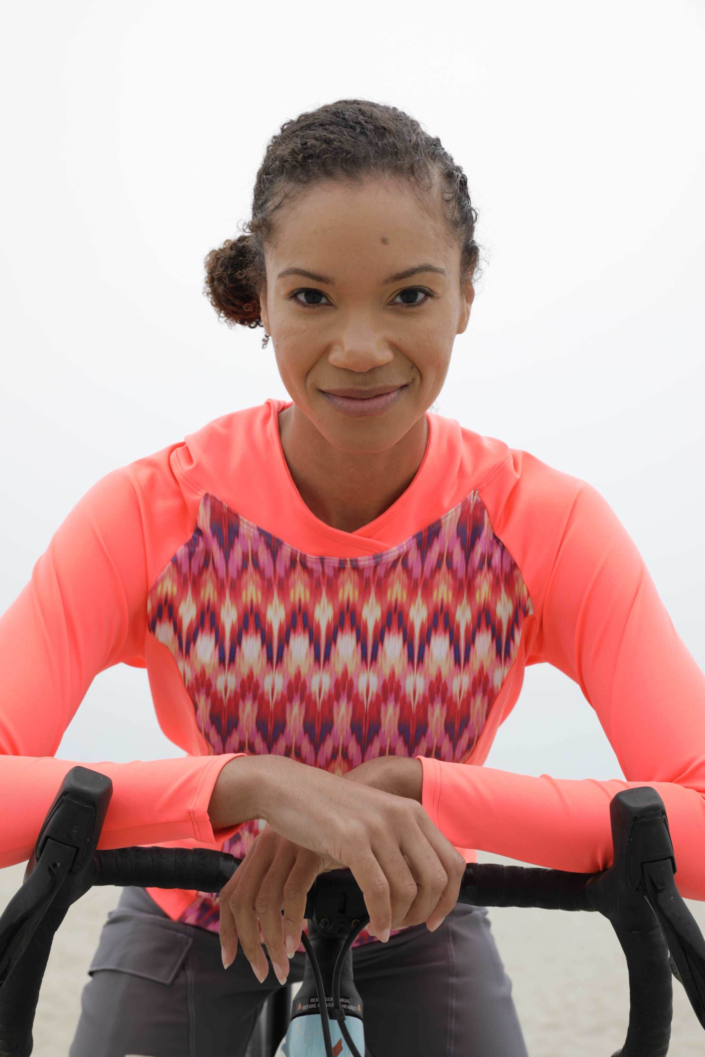 Moxie Tee Heavier Weight hoodie, long sleeve, high visibility, moisture-wicking fabric, woman on a bicycle.