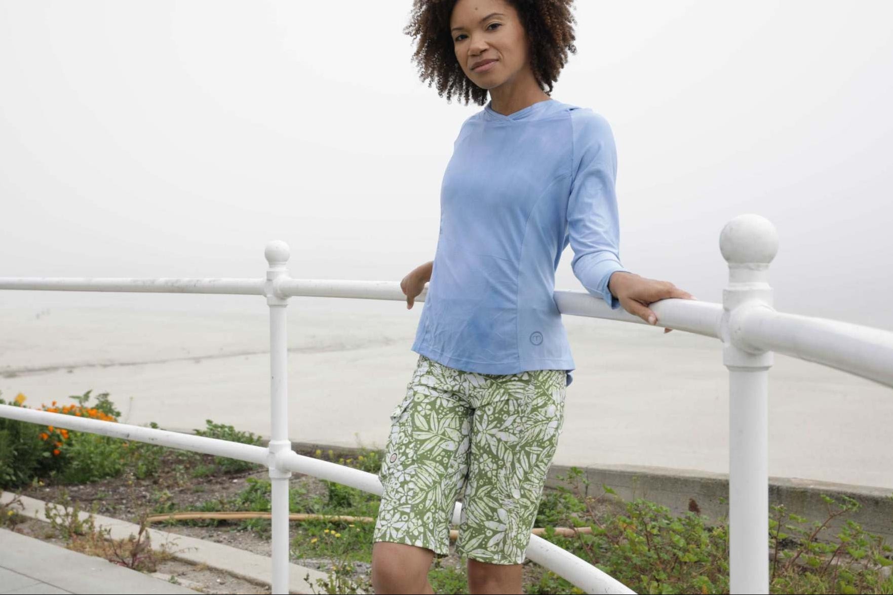 Woman wearing Mountain Short-Peace Leaf trail-ready shorts, outdoor setting.