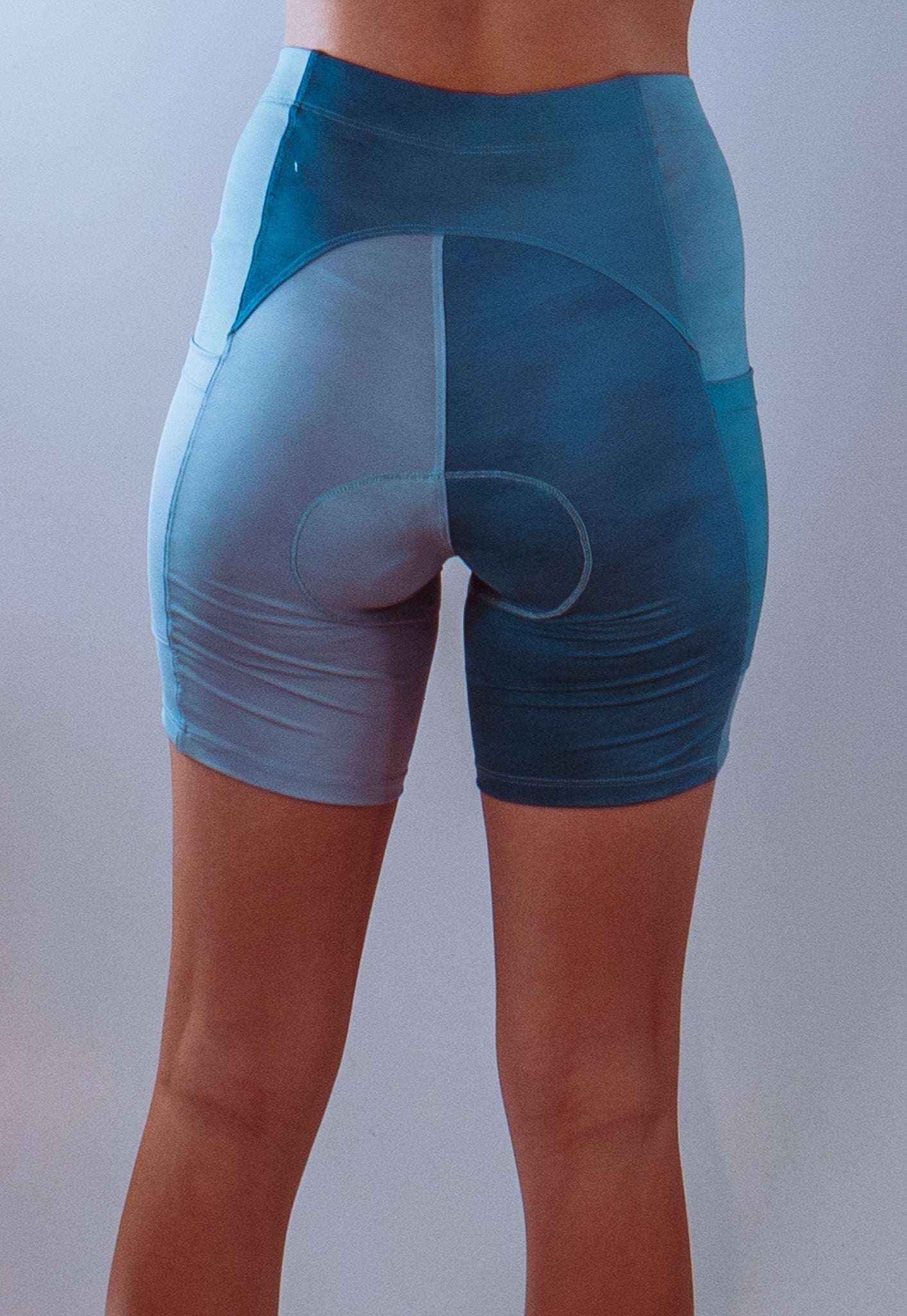 Women's bike shorts with 7" inseam and Italian chamois, featuring recycled stretch poly spandex and performance moisture-wicking fabric in baby blue color.