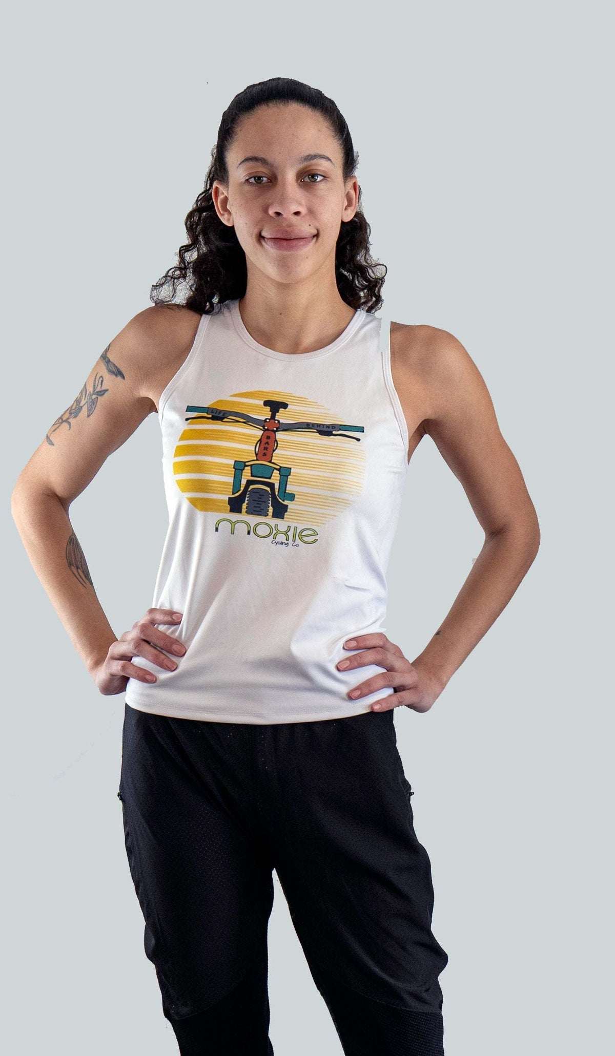 Women's sleeveless cycling jersey with Dirt and Ink cycling graphic.  White base fabric with mountain bike handles graphic stating Life Behind Bars