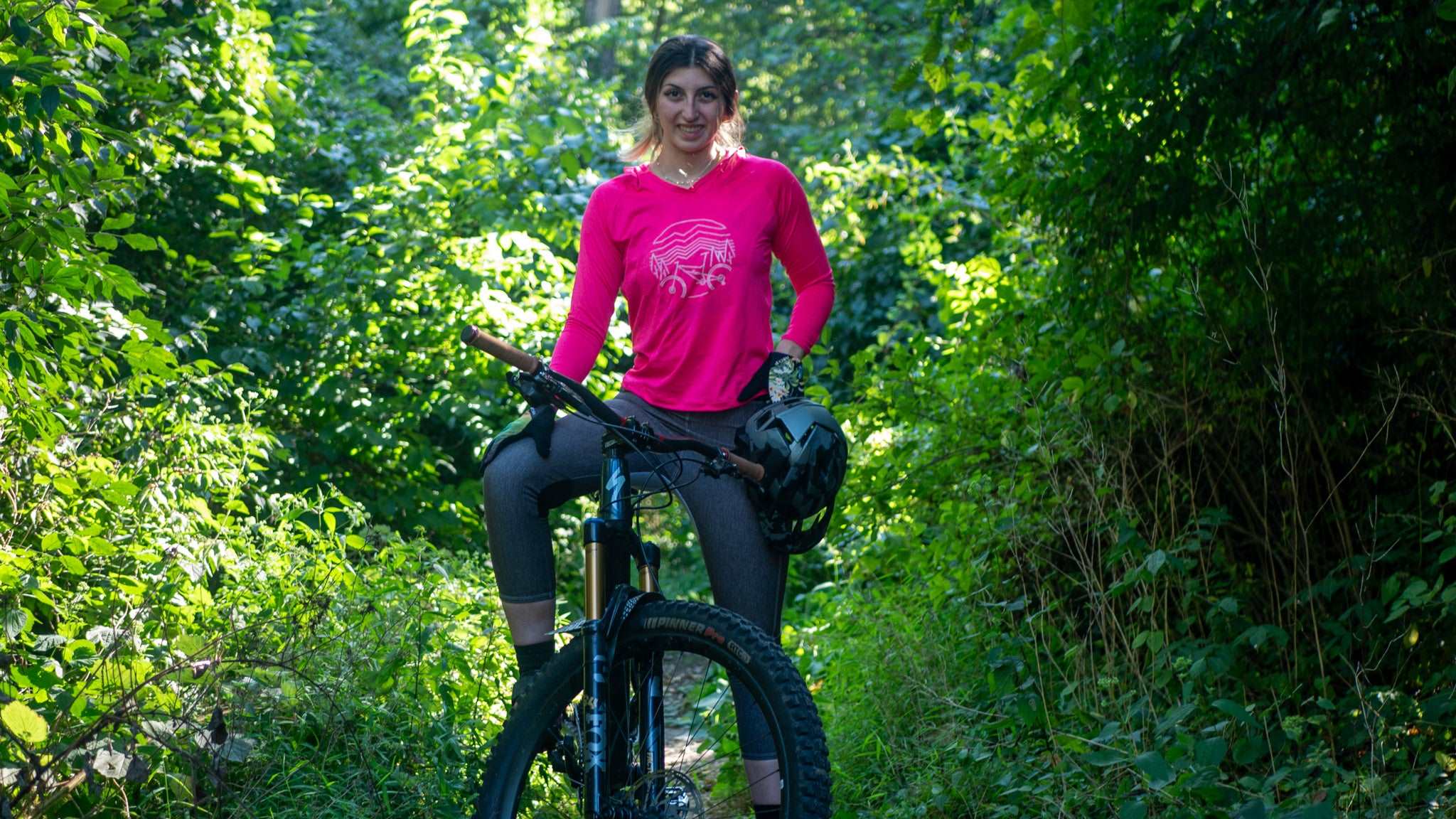 woman wearing women's mountain bike pants in lush forest setting