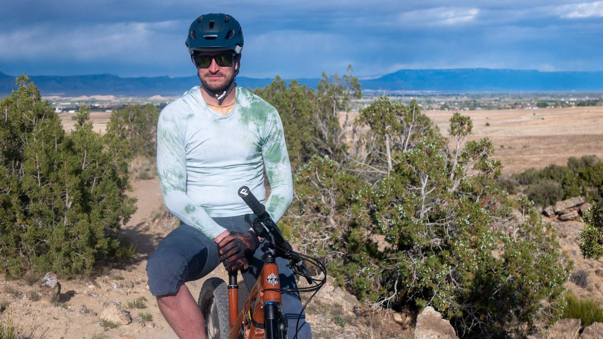 All Gender Hoodie worn by cyclist in outdoor setting, showcasing its weather performance and visibility features.