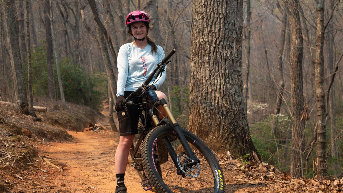 Moxie Sun Saver Hoodie worn by cyclist in forest trail.