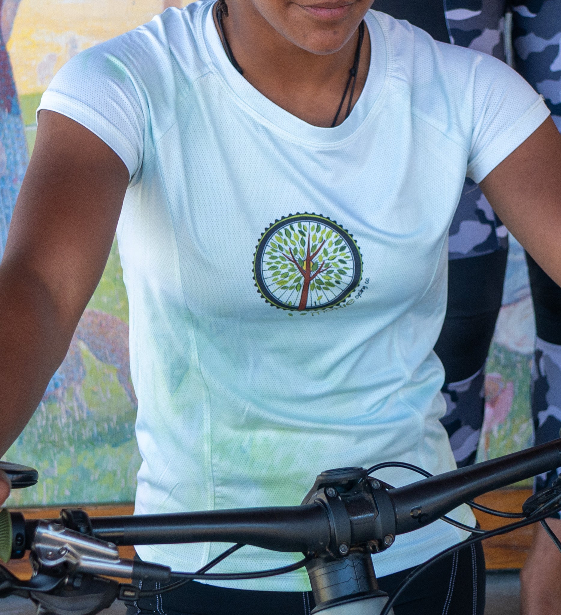 Women wearing Moxie Tee Cycling Jersey with Tree of Life graphic and perforated mesh fabric