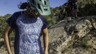 Woman wearing Moxie Tee Jersey on mountain bike trail with helmet and sunglasses