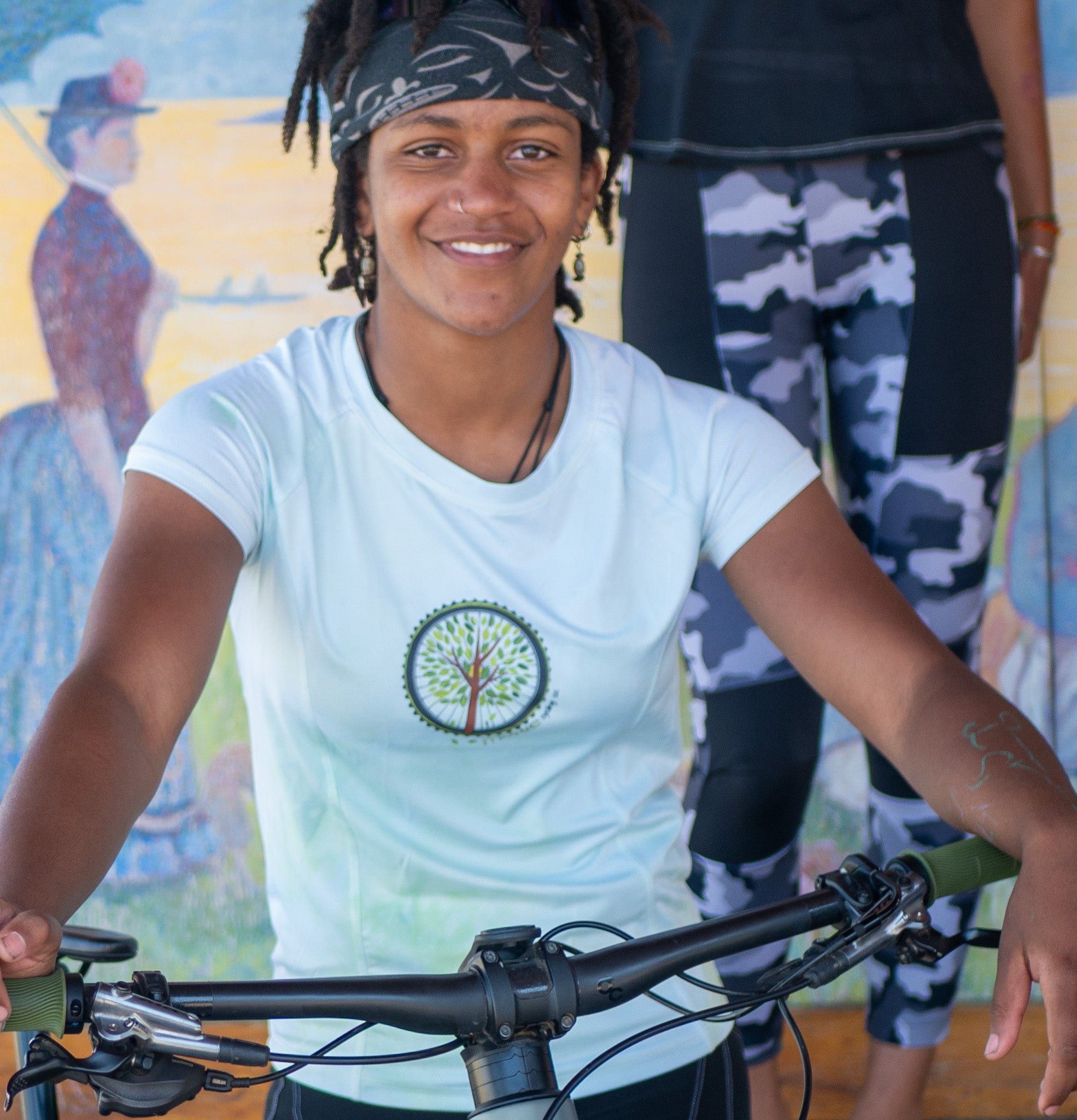 Women wearing Moxie Tee Cycling Jersey with Tree of Life graphic biking outdoors