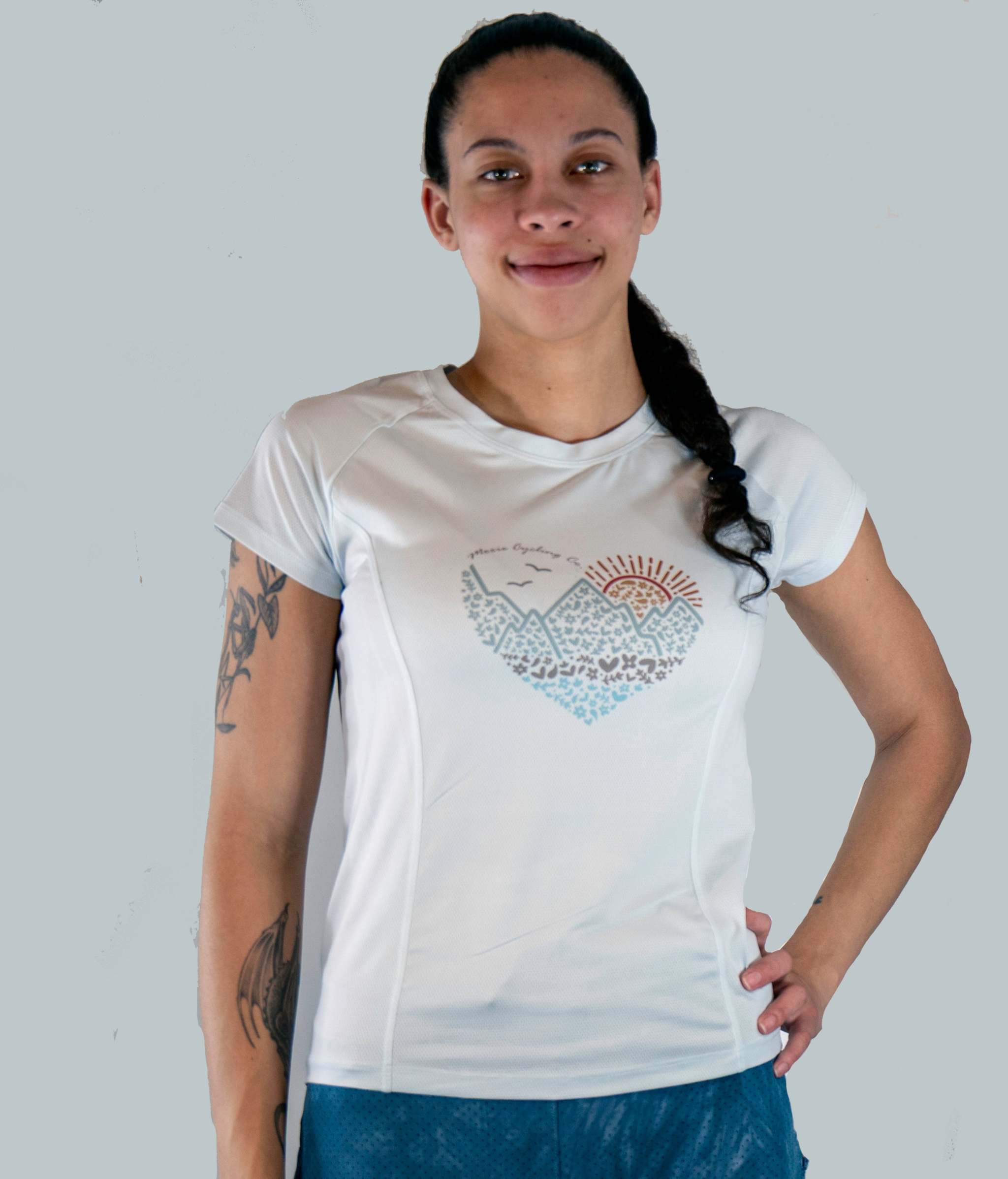Woman wearing a white t-shirt with a graphic design on a plain background