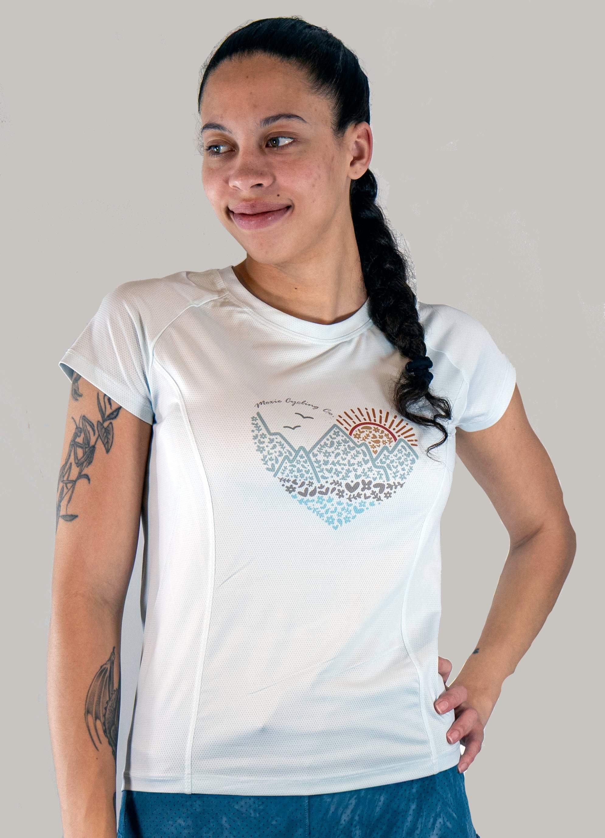 Woman wearing a white t-shirt with a graphic design on a plain background