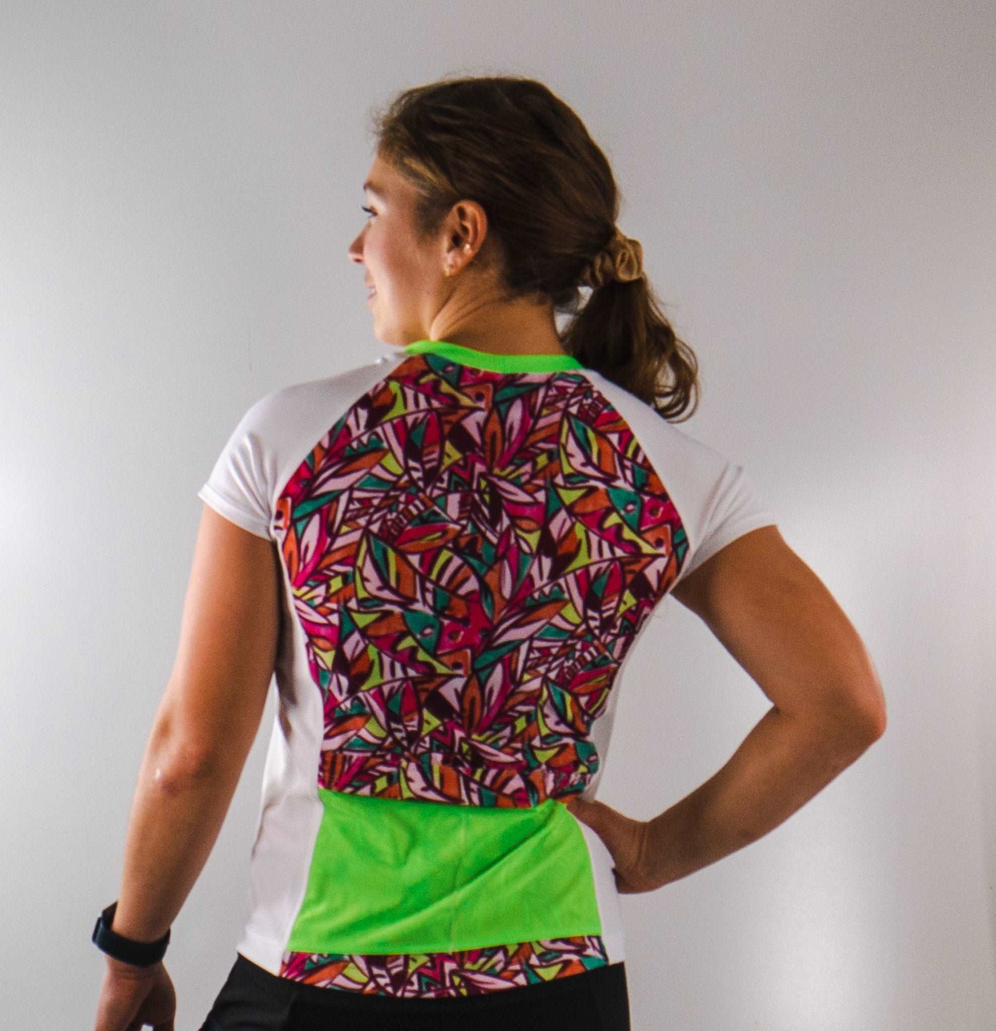 Moxie Tee Jersey Fifi with colorful back design, moisture-wicking fabric, and dual back pockets.