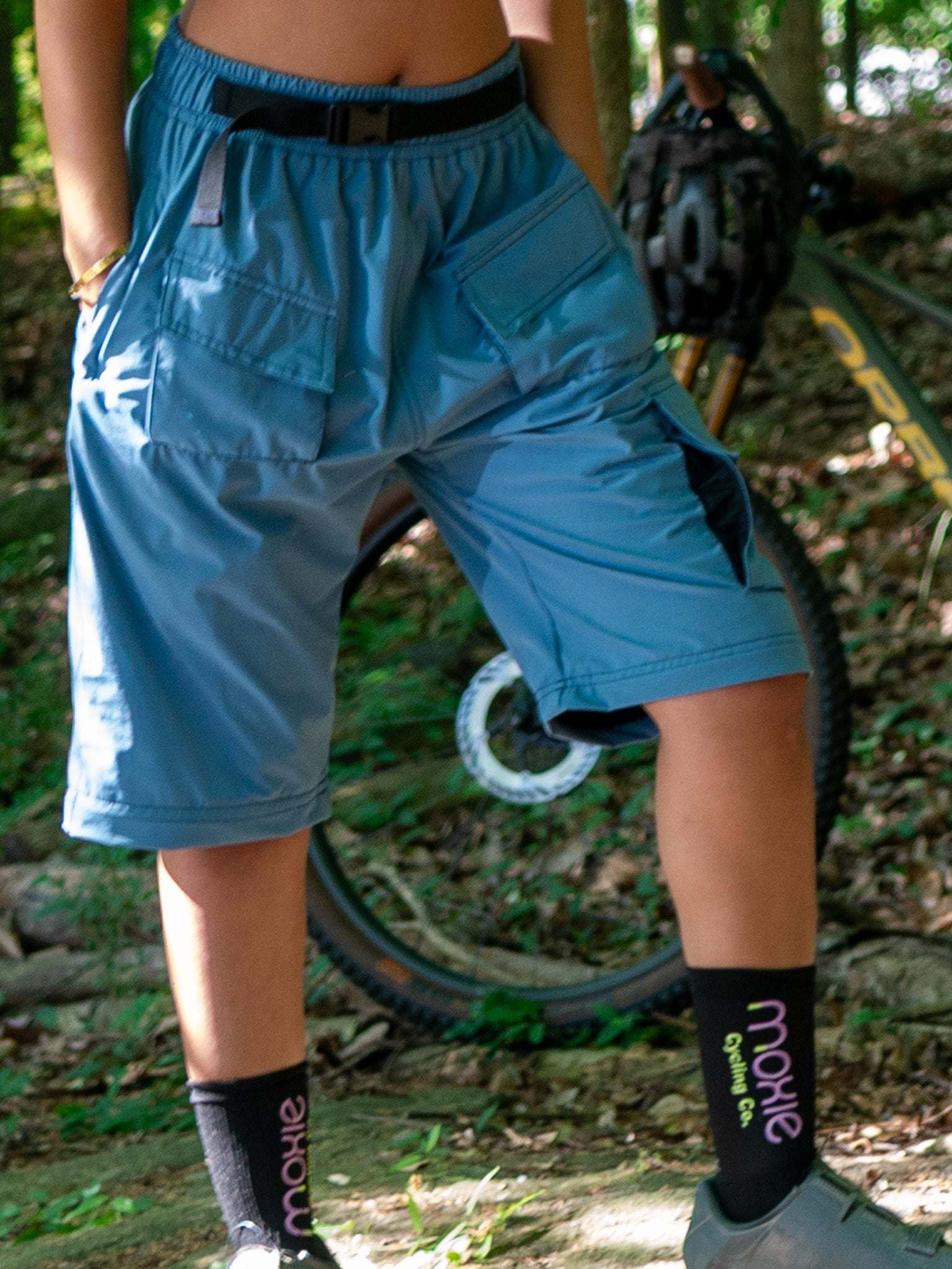 Women’s mountain bike pants in dusty blue with cargo pockets designed for versatility and technical performance