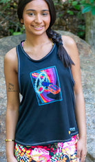 Woman wearing Moxie Tech Tank breathable mesh cycling jersey with Ride Bikes Be Happy graphic on a mountain bike trail