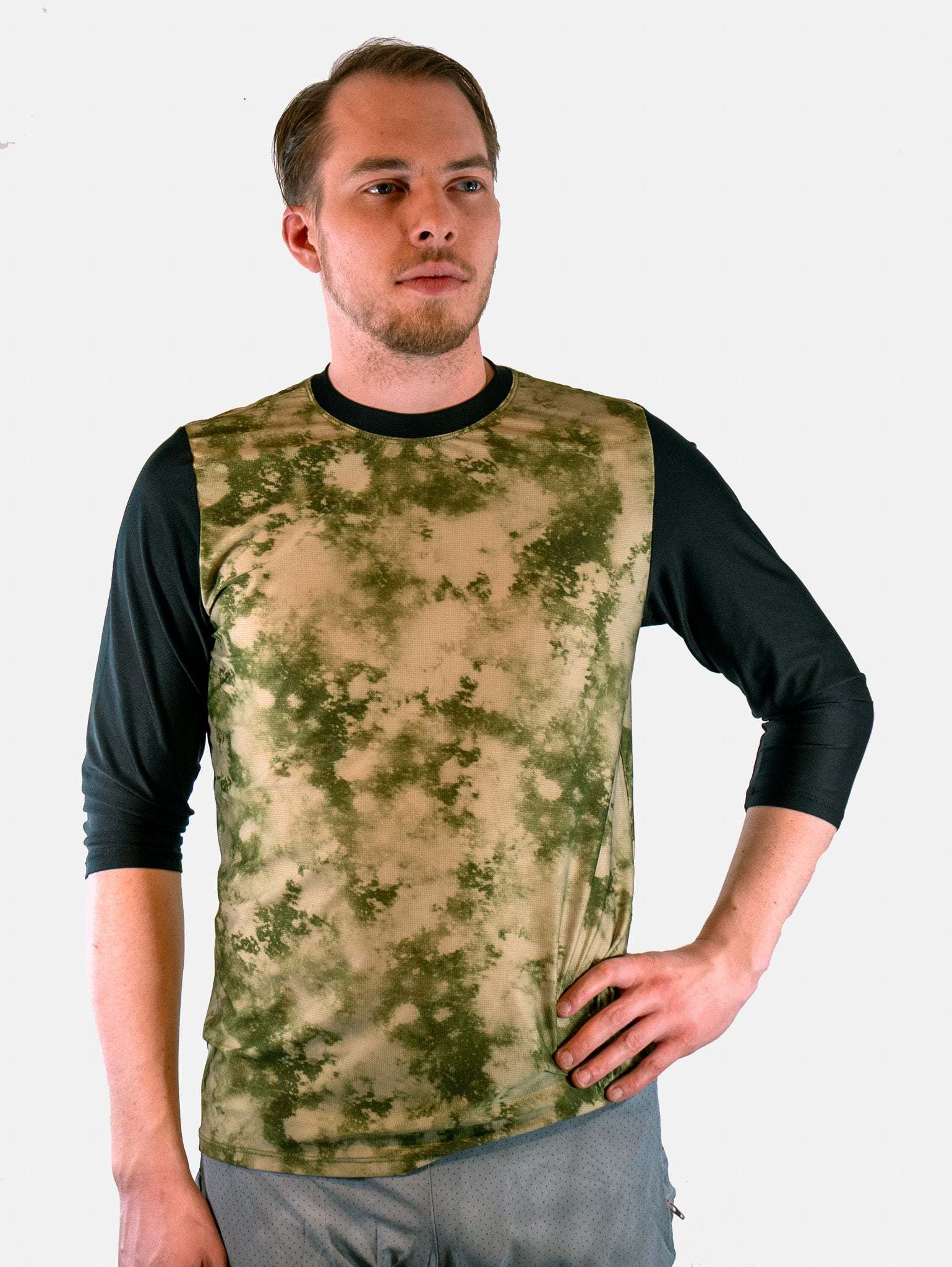 Man wearing a camouflage long-sleeve shirt on a white background