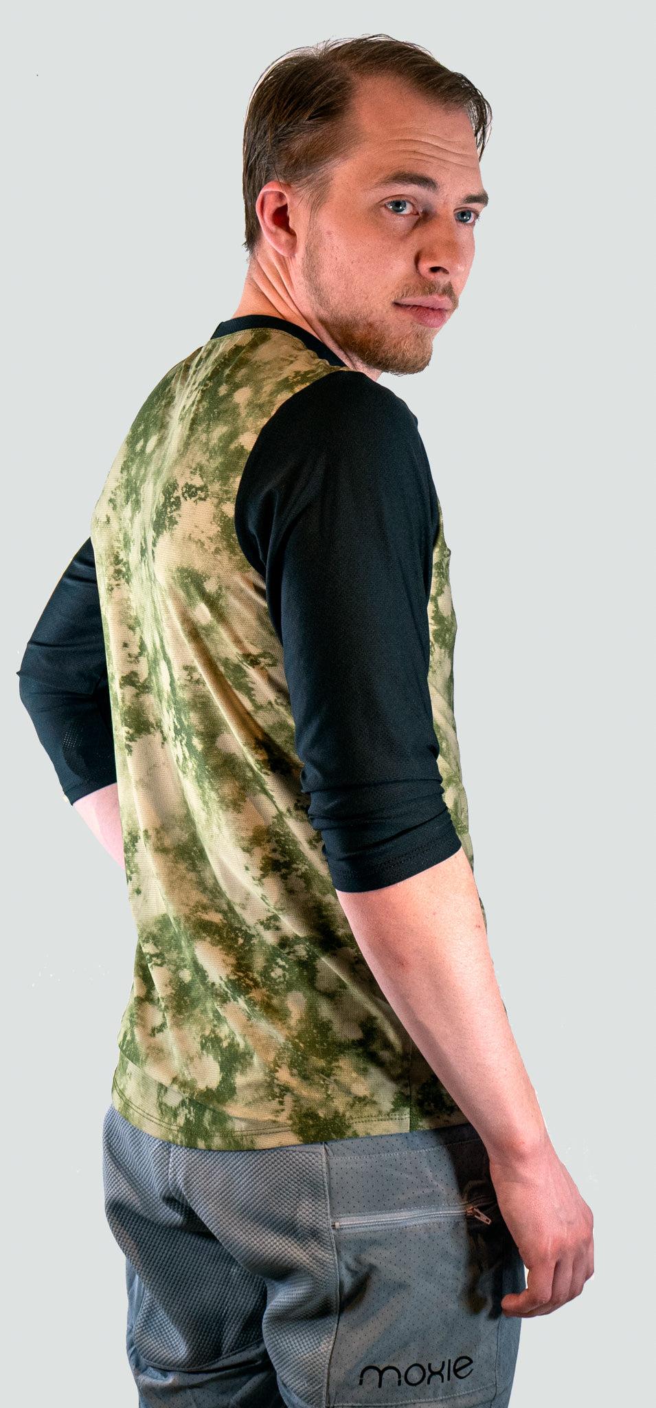 Man wearing a camouflage shirt with a plain background