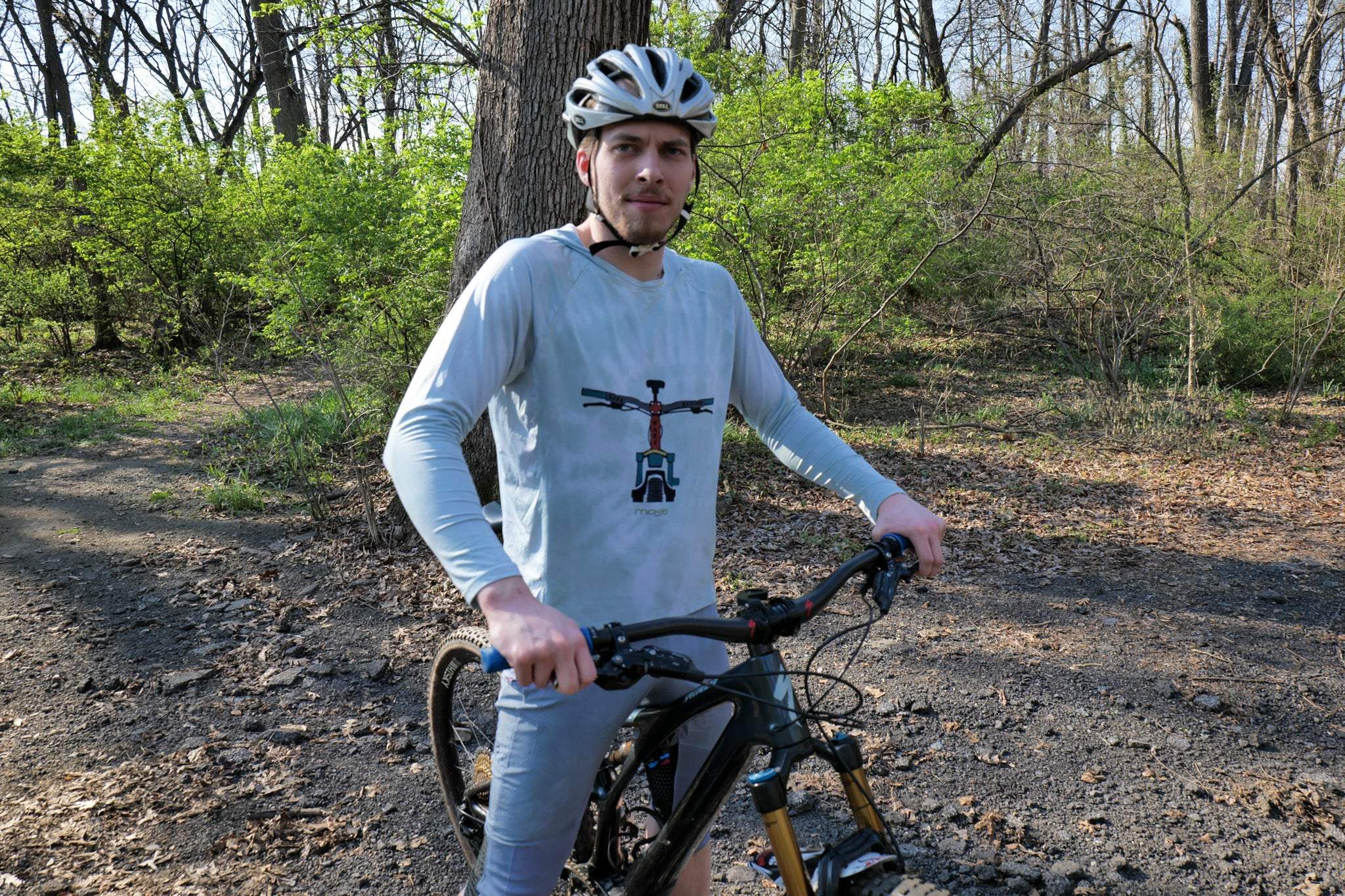 Man with a bicycle in a forest setting