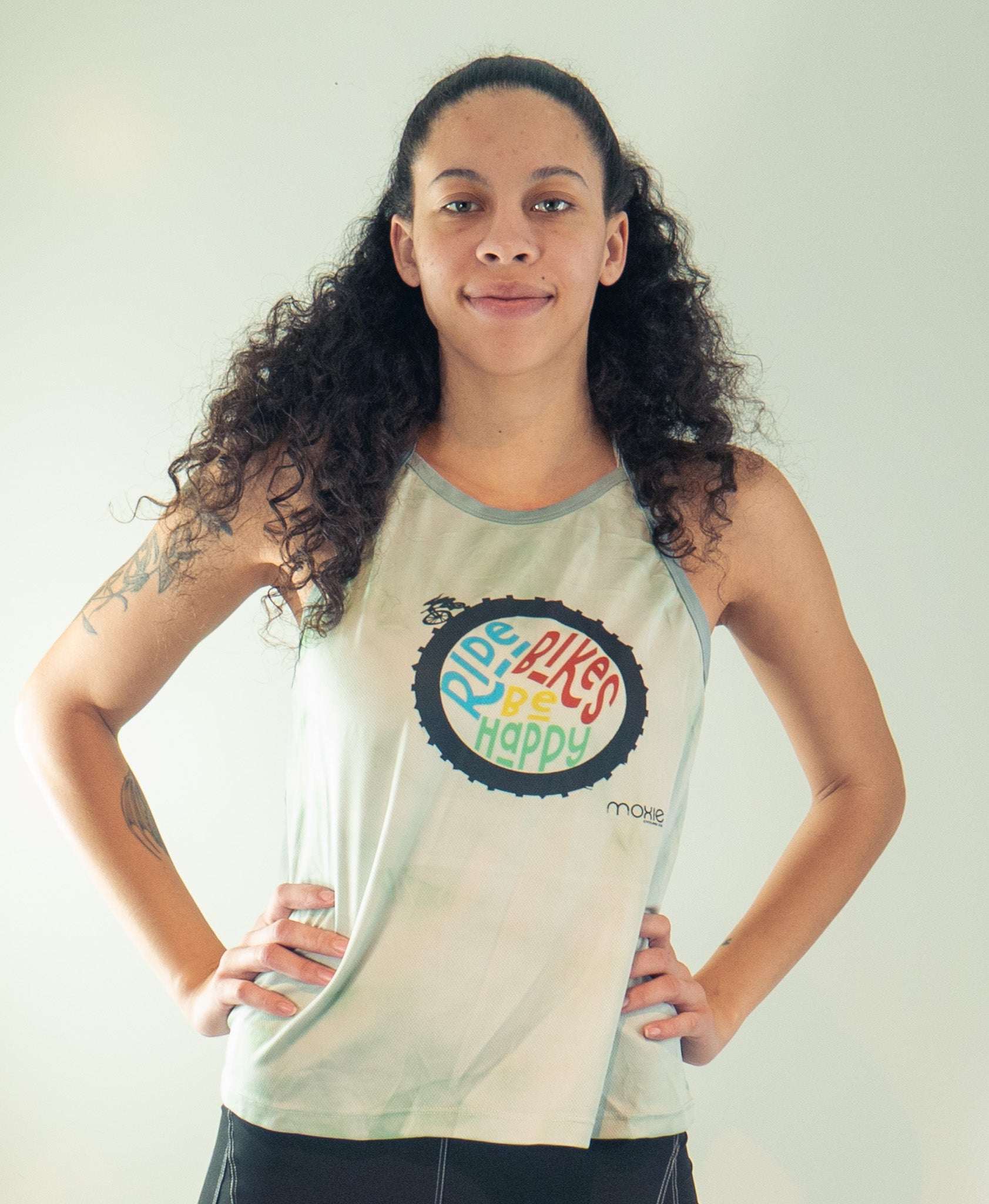 Women's sleeveless tie dye bike top with Ride Bikes Be Happy graphic and back pocket for cycling.