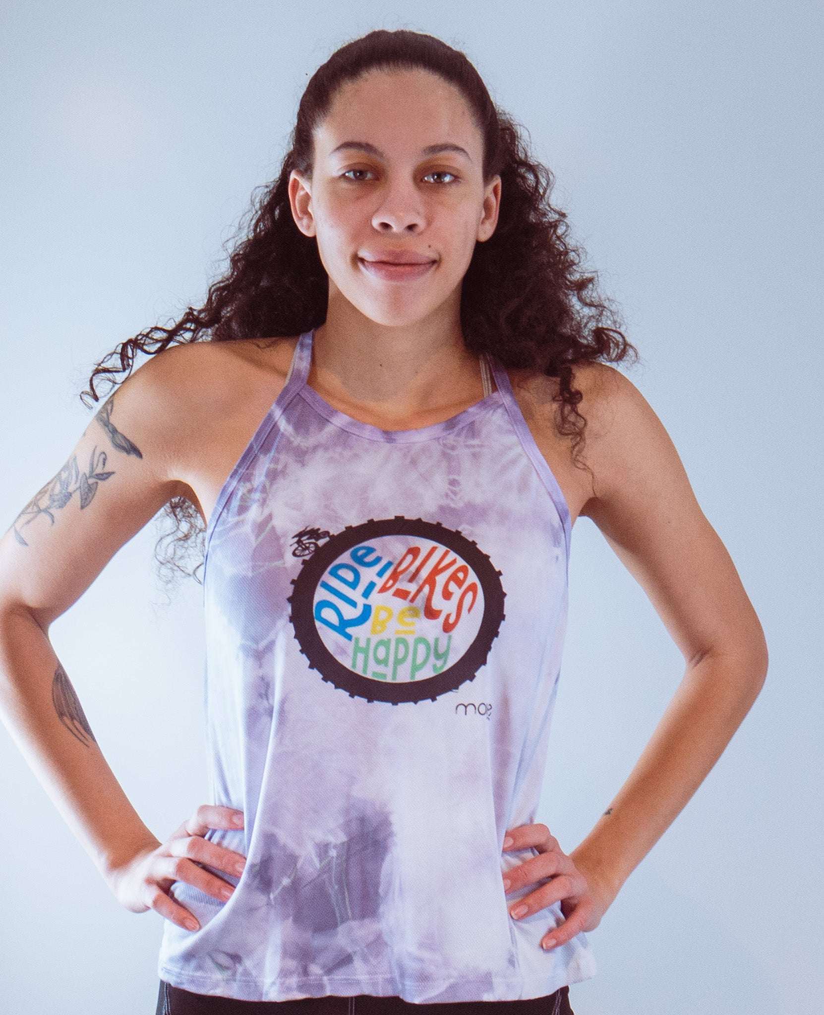 Women's sleeveless tie dye bike top with "Ride Bikes Be Happy" graphic and back pocket, made from soft performance spandex