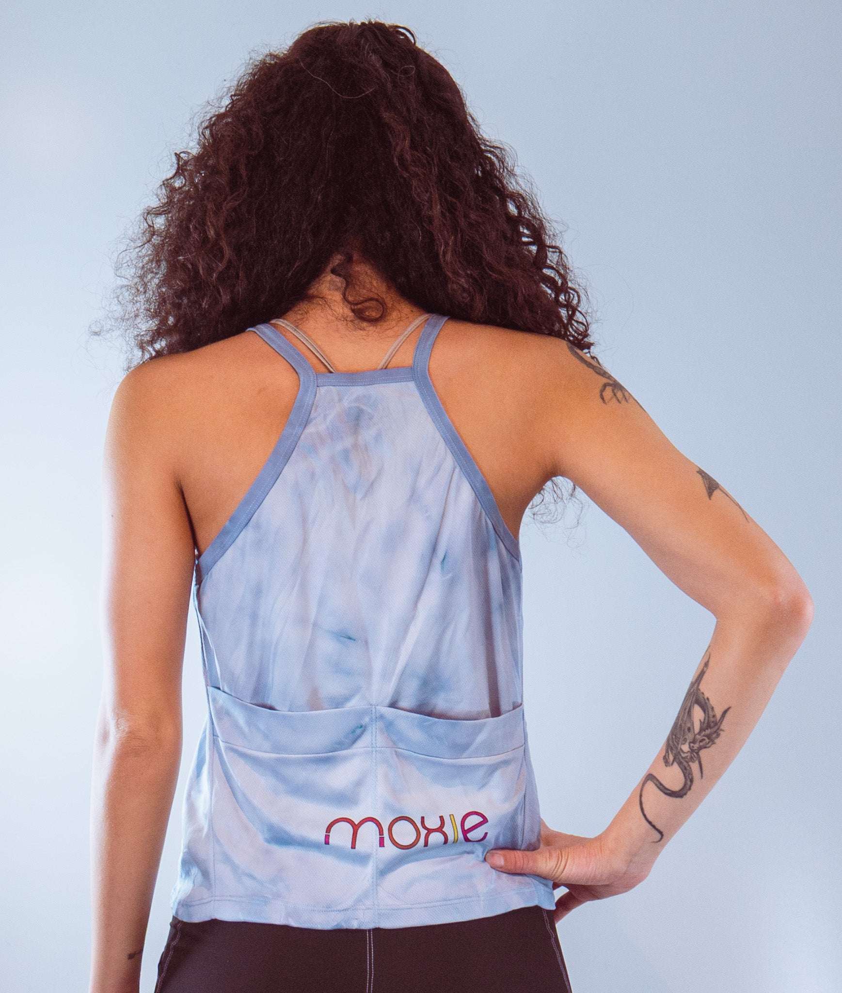 Women's sleeveless tie dye bike top with back pockets and strappy design, made from soft performance spandex.