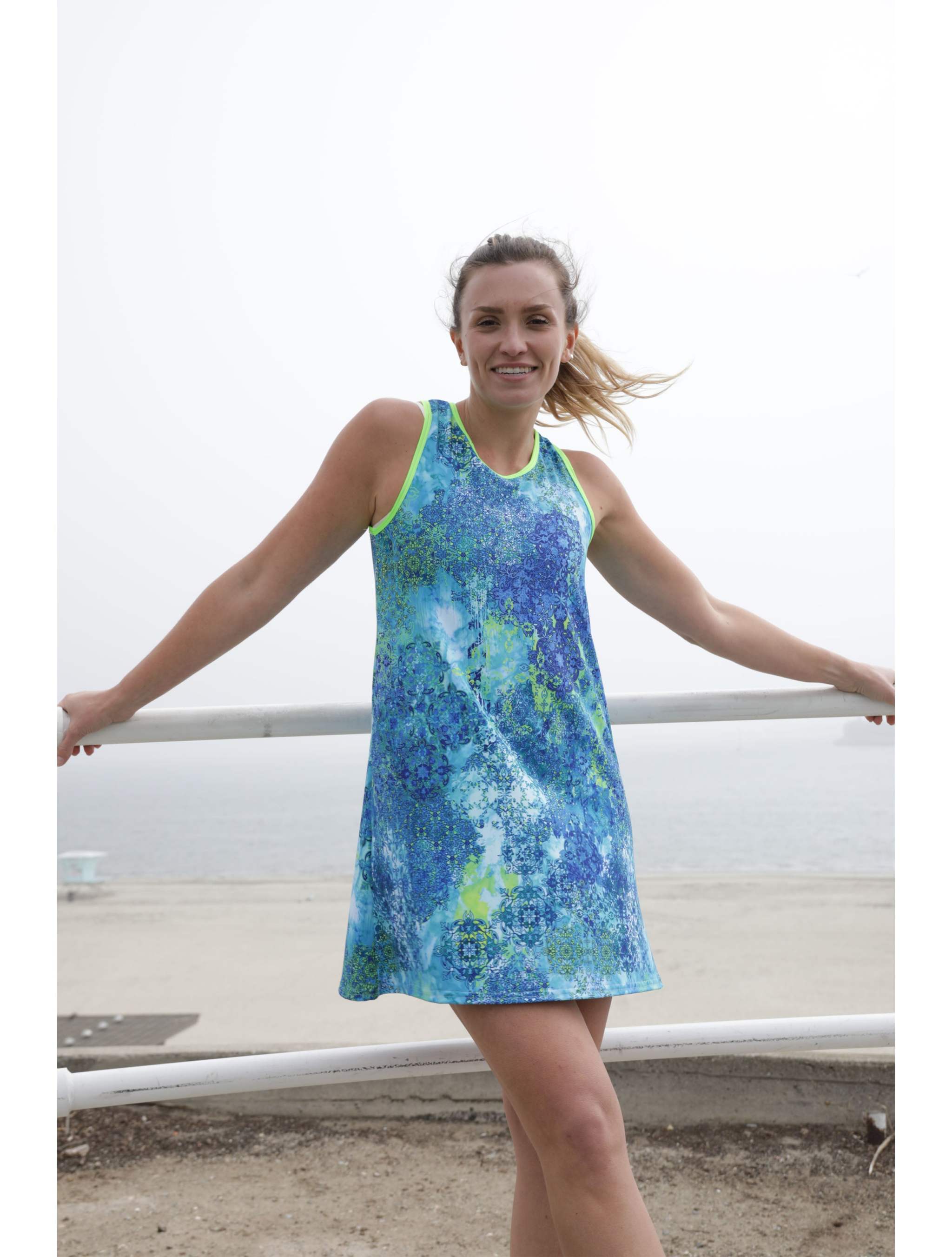 Woman wearing blue floral patterned sporty A-line dress by the beach