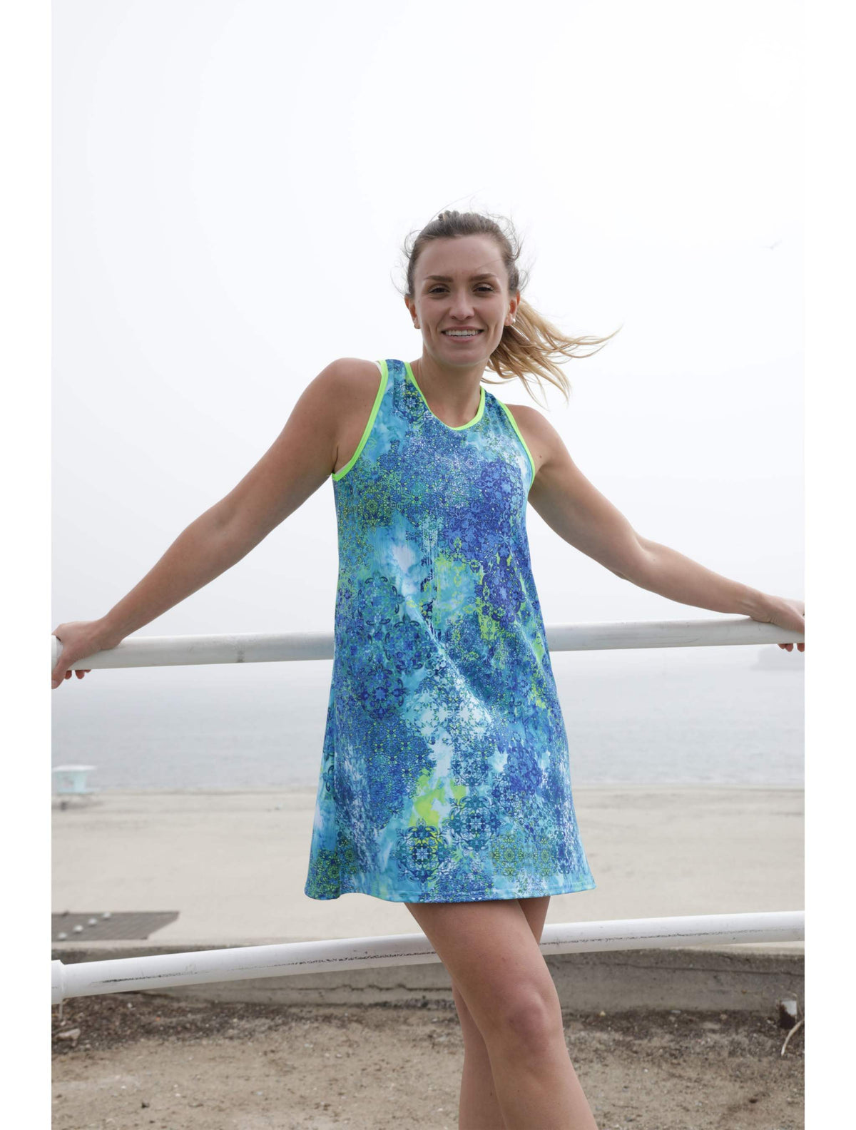 Woman wearing blue floral patterned sporty A-line dress by the beach