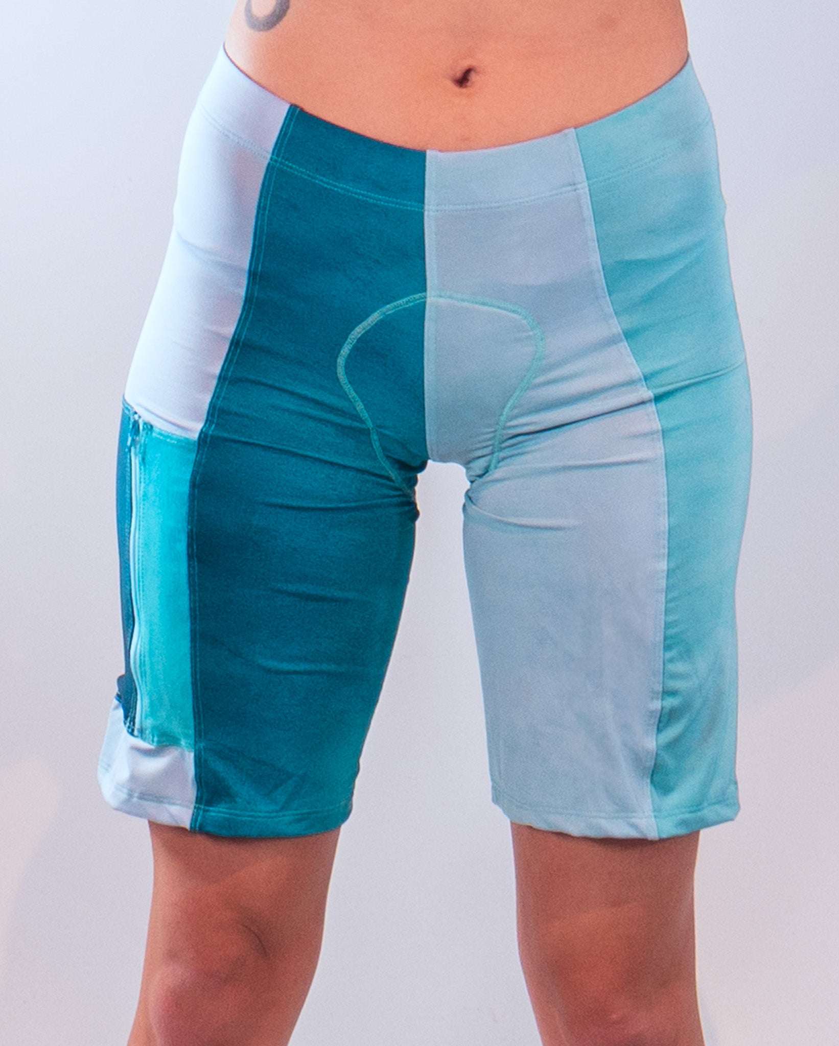 Mountain bike shorts with Italian chamois, moisture-wicking fabric, and large side pocket in shades of blue.