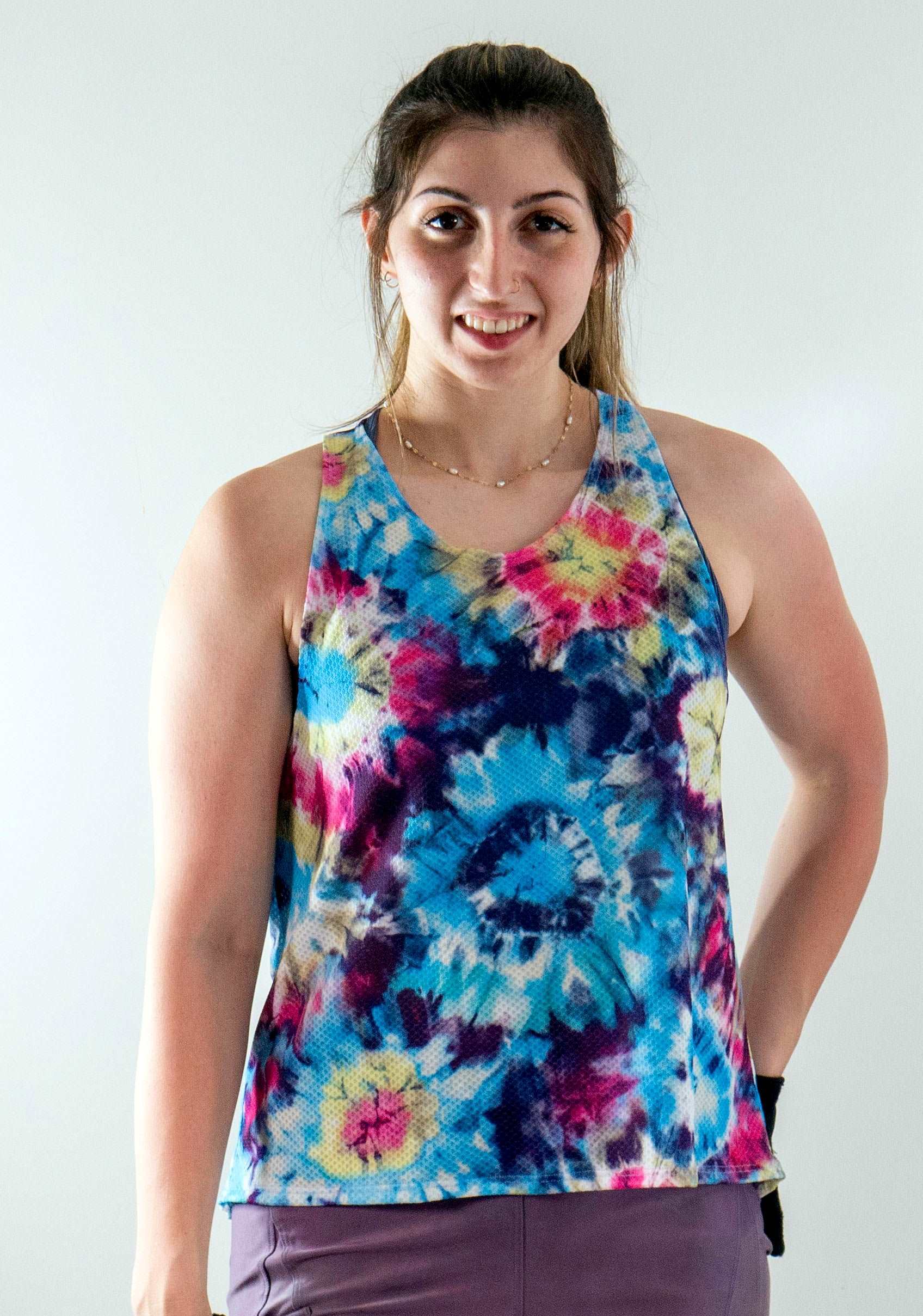 swifly tech tank worn by a person, showcasing breathable, lightweight sporty design in colorful mesh fabric.