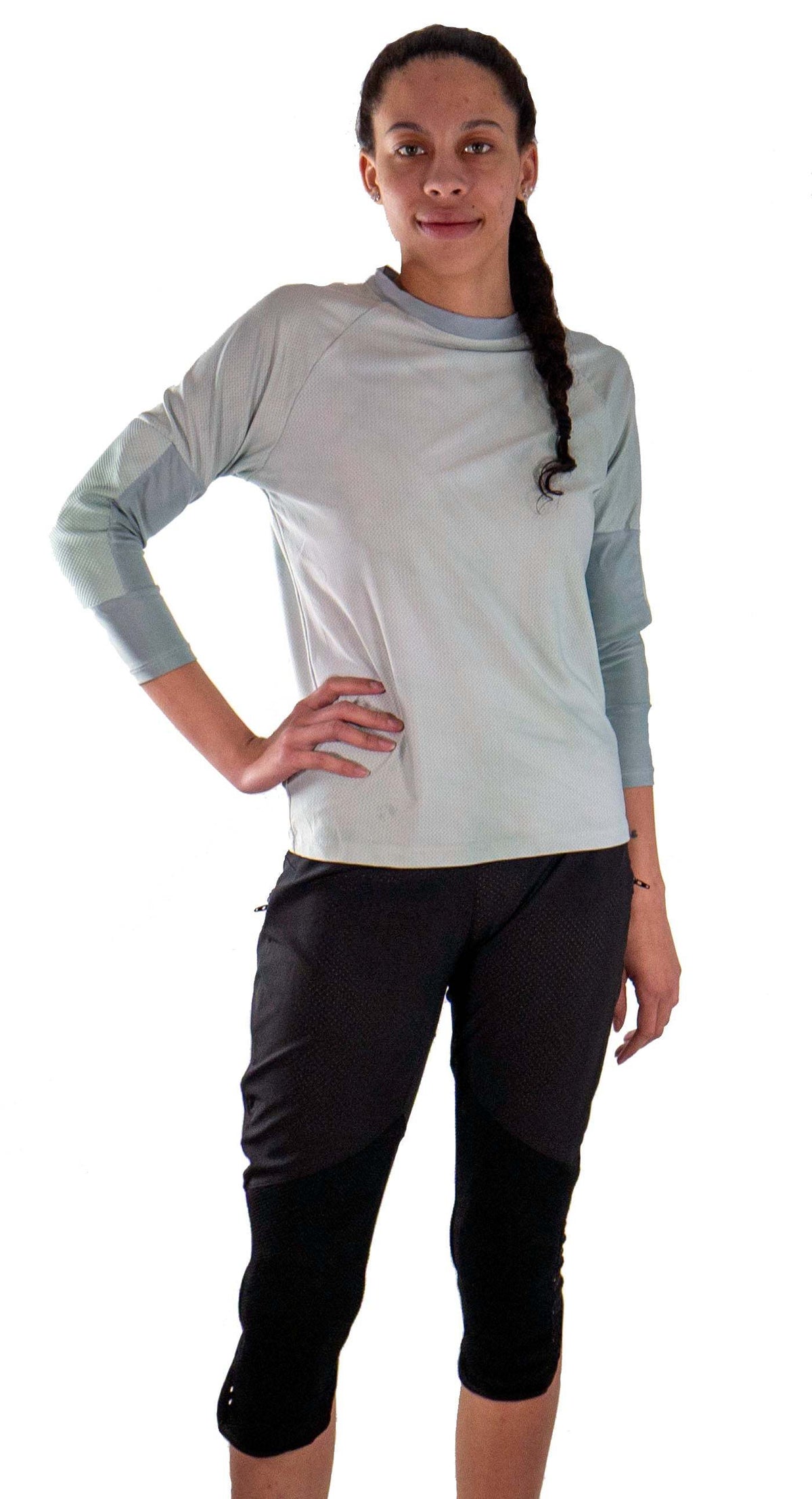 Woman wearing black women's mountain bike pants with removable G-Form hip and knee pads and a gray long-sleeve shirt