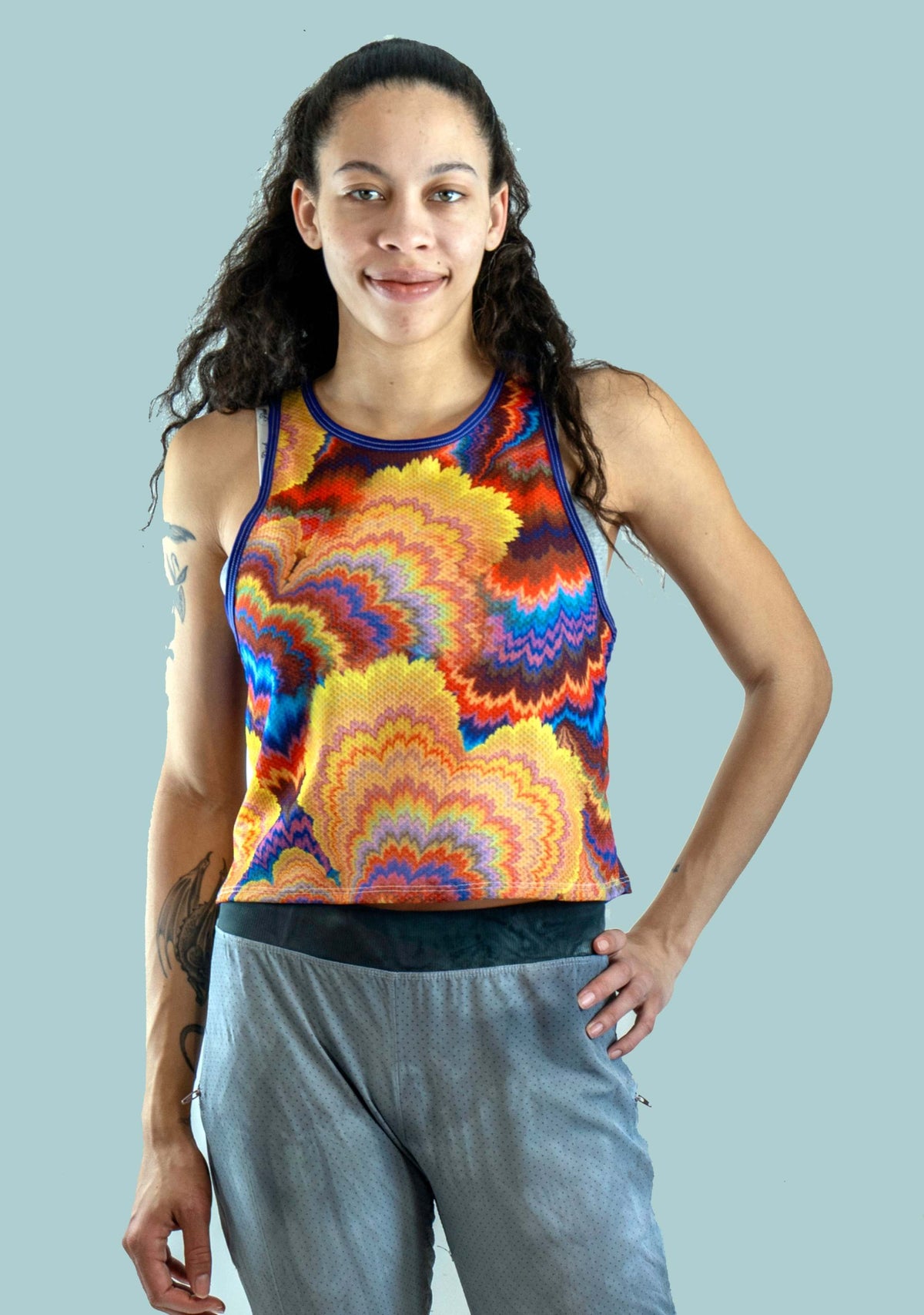 Woman wearing waffle-knit cropped tank mountain bike jersey riding bike outdoors