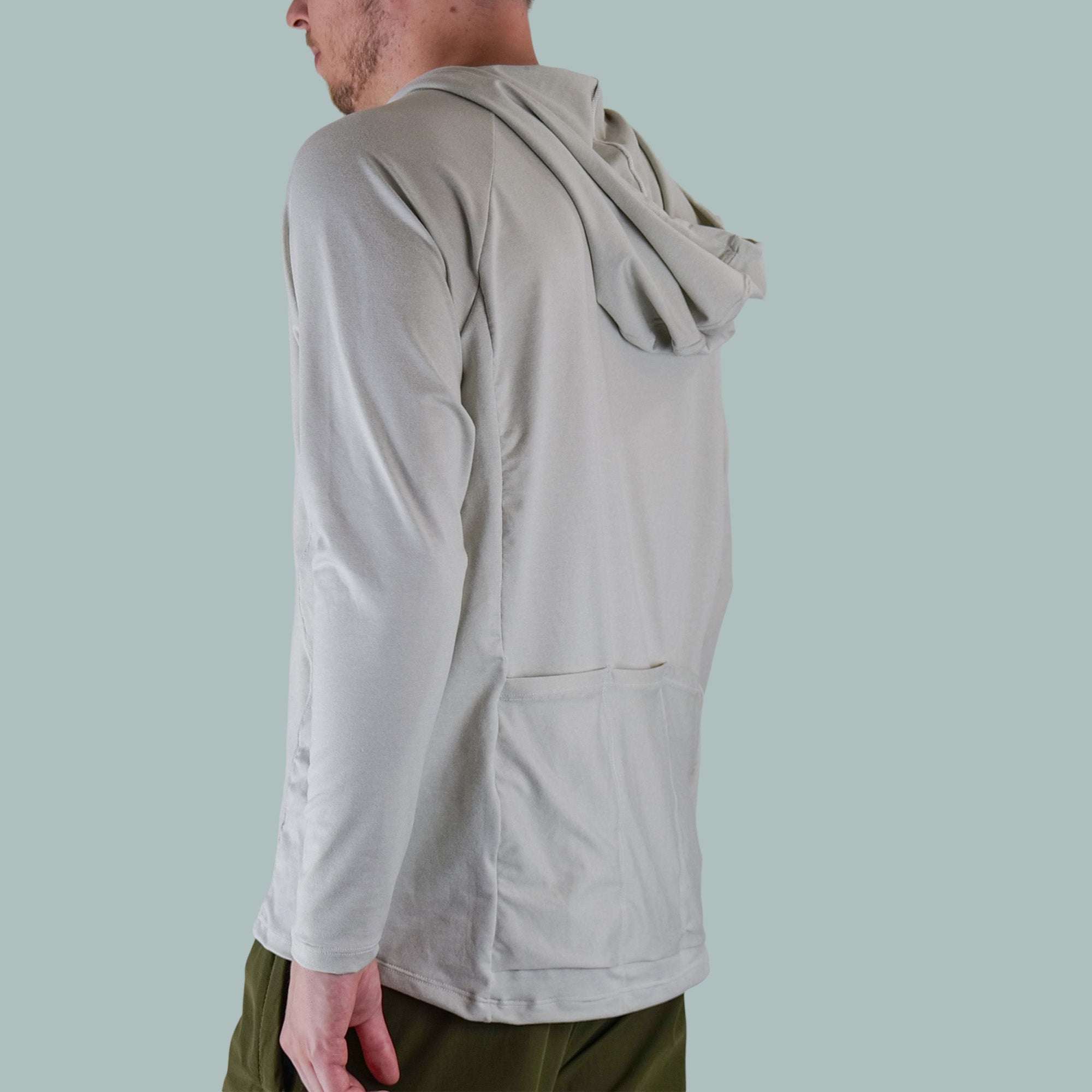 Men's Fall Cycling Hoodie in light gray with long sleeves, a hood, and a rear pocket, worn with olive green pants.
