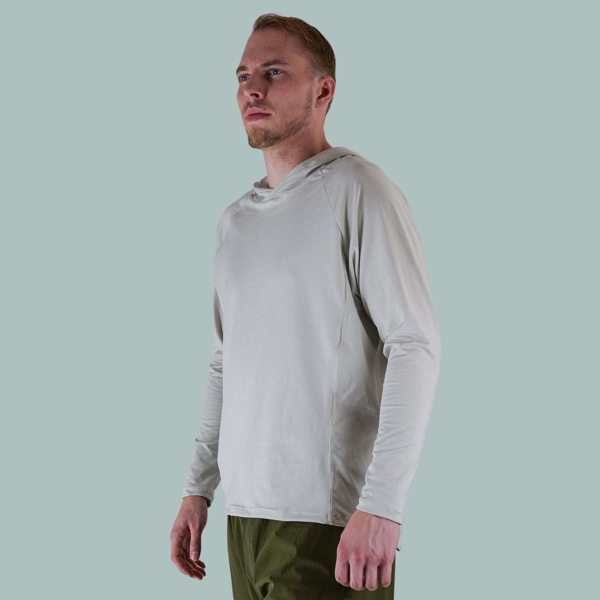 Men's Fall Cycling Hoodie in light grey with long sleeves and a hood, worn with olive green pants by a male model.
