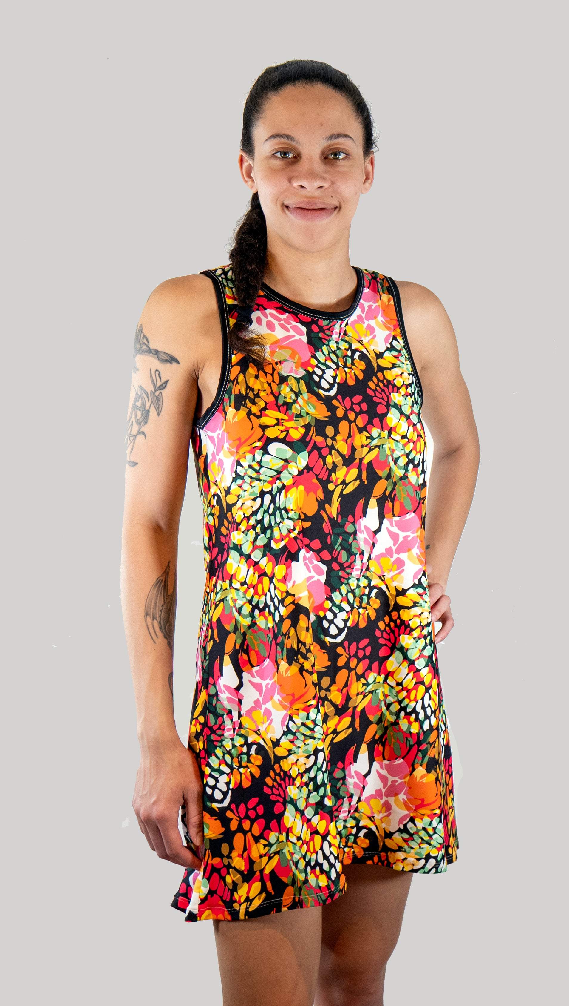 Woman wearing a colorful floral dress against a gray background