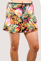 Colorful floral skirt worn by a person on a plain background