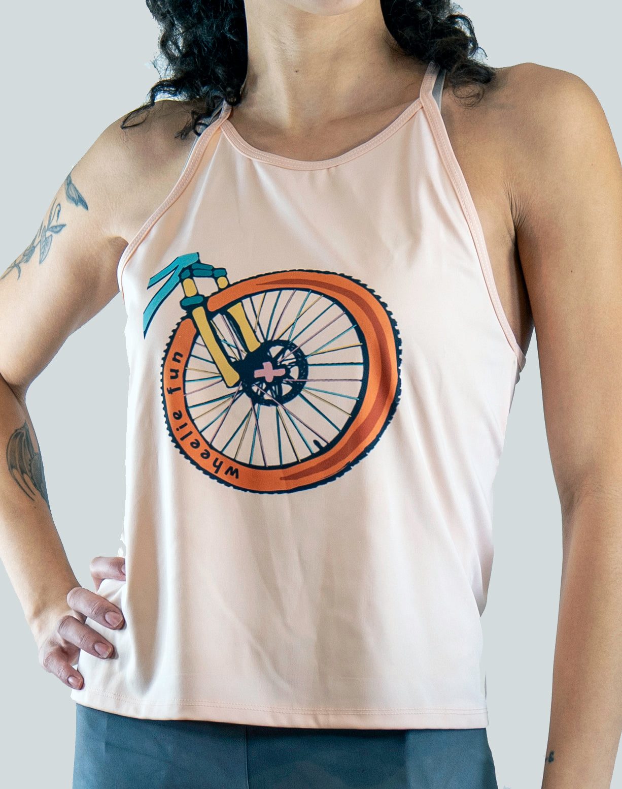 Person wearing a tank top with a bicycle graphic design on a plain background