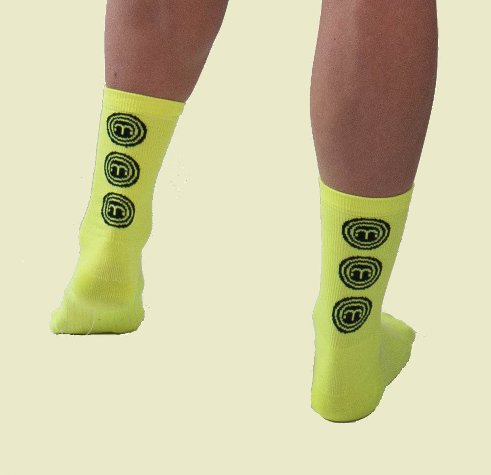 Hi Vis Moxie Socks with black circle design, moisture-wicking, 6-inch cuff.