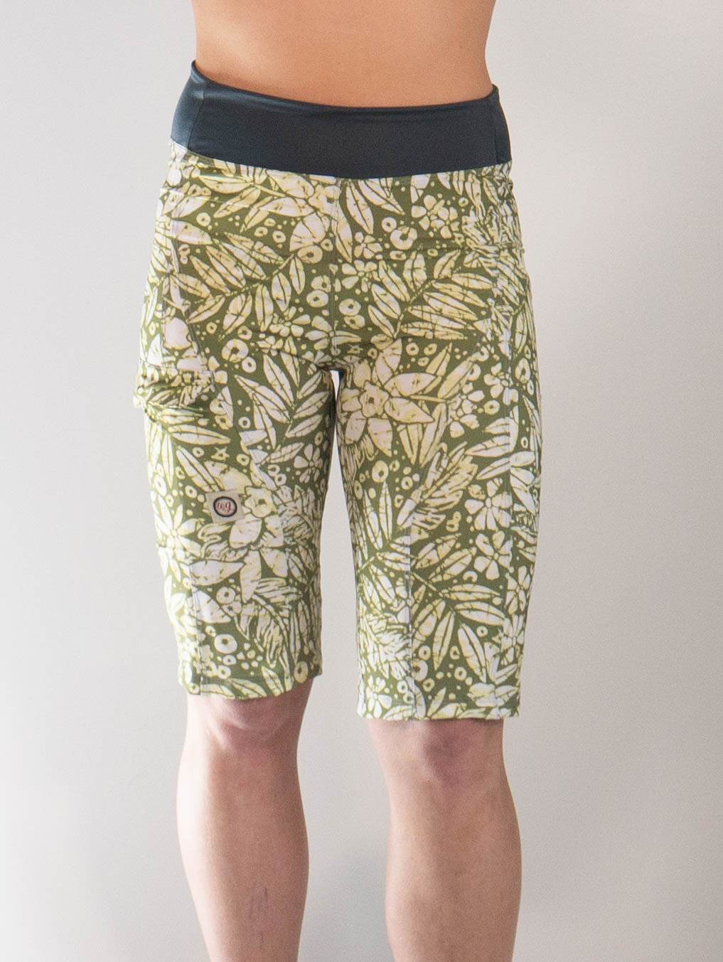 Woman wearing Mountain Short-Peace Leaf women's mountain bike shorts with green leafy pattern and black waistband.